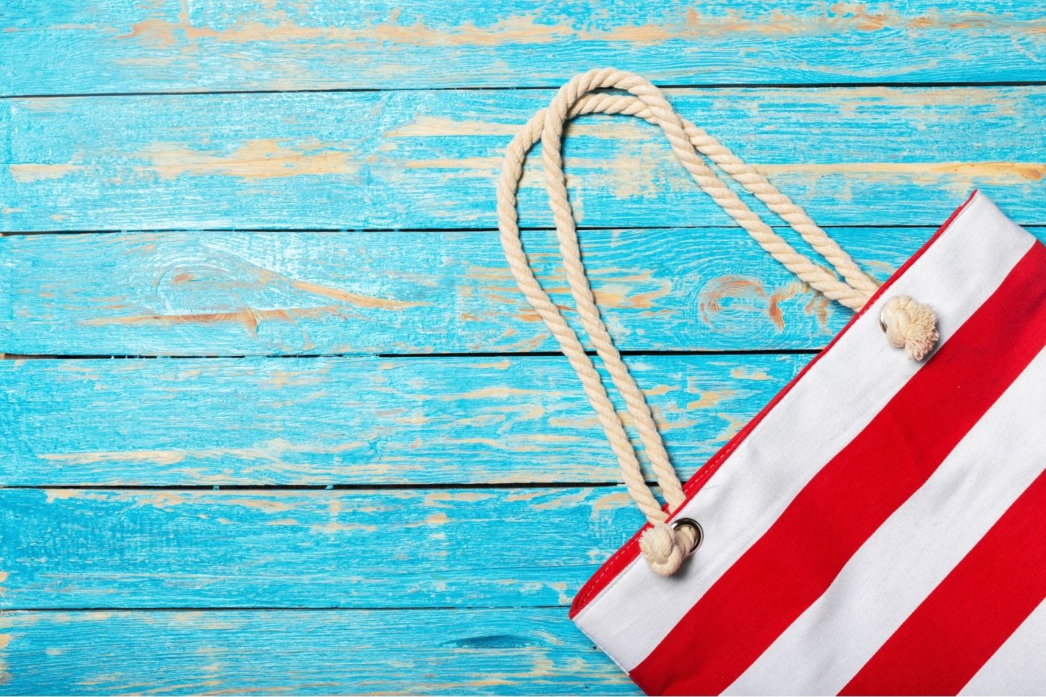 Red and white beach bag on a picnic table