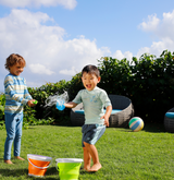 Two boys happily playing together on a Hawaiian beach, both wearing UV Skinz UPF 50+ swimwear and rash guards, well-protected from the sun’s rays as they splash in the water and enjoy outdoor fun.