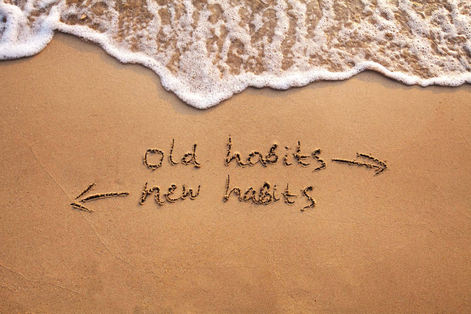 old habits and new habits written in sand