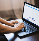 woman typing on a lap top indoors