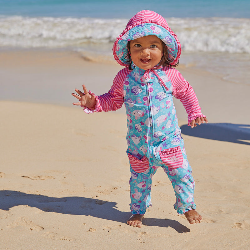 Little girl in UV Skinz's baby girls long-sleeve swimsuit in sea bunnies|sea-bunny-stripes