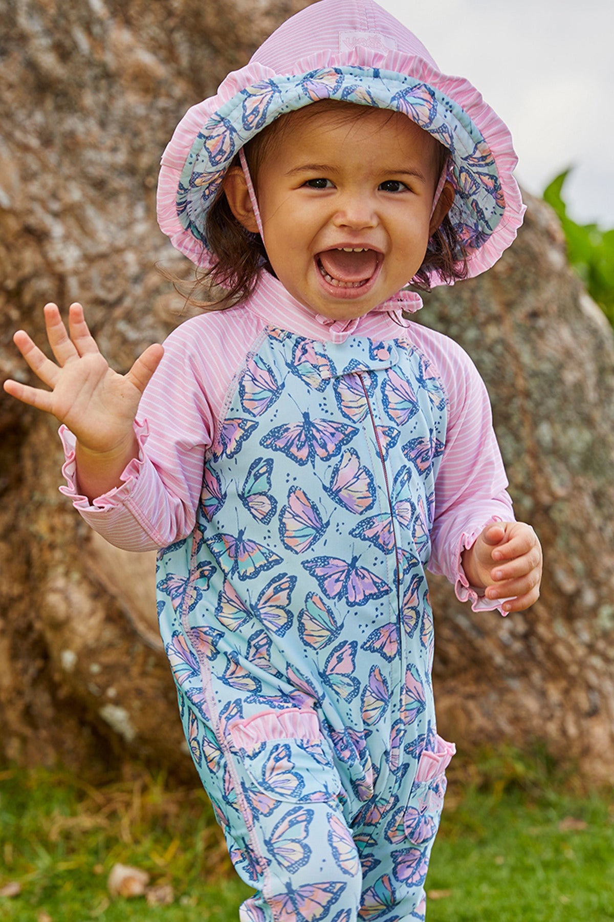 Little baby girl in UV Skinz's baby girls long-sleeve swimsuit in sweet butterflies