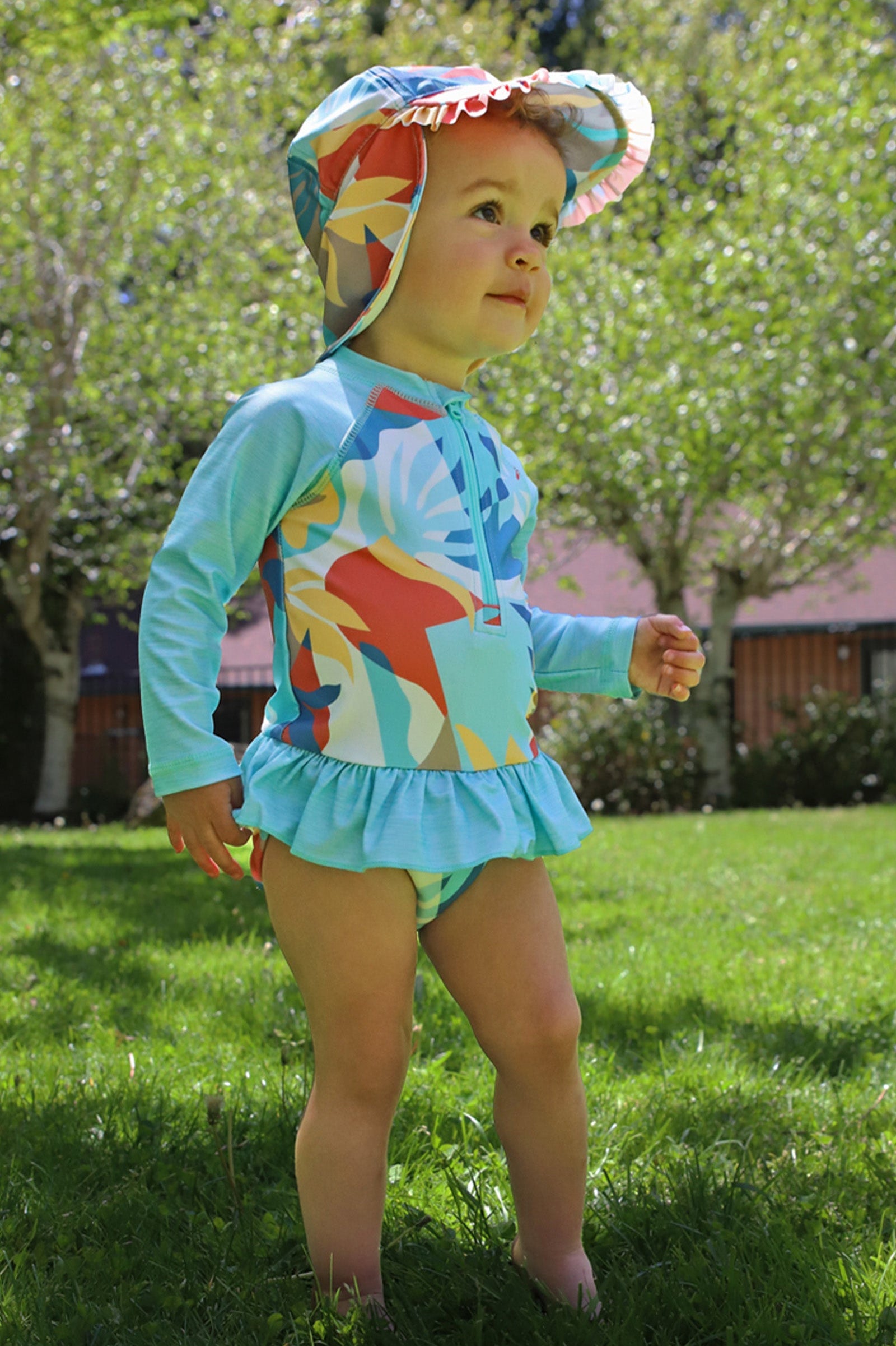 baby girl in long sleeve ruffled swim suit in beach picasso|beach-picasso