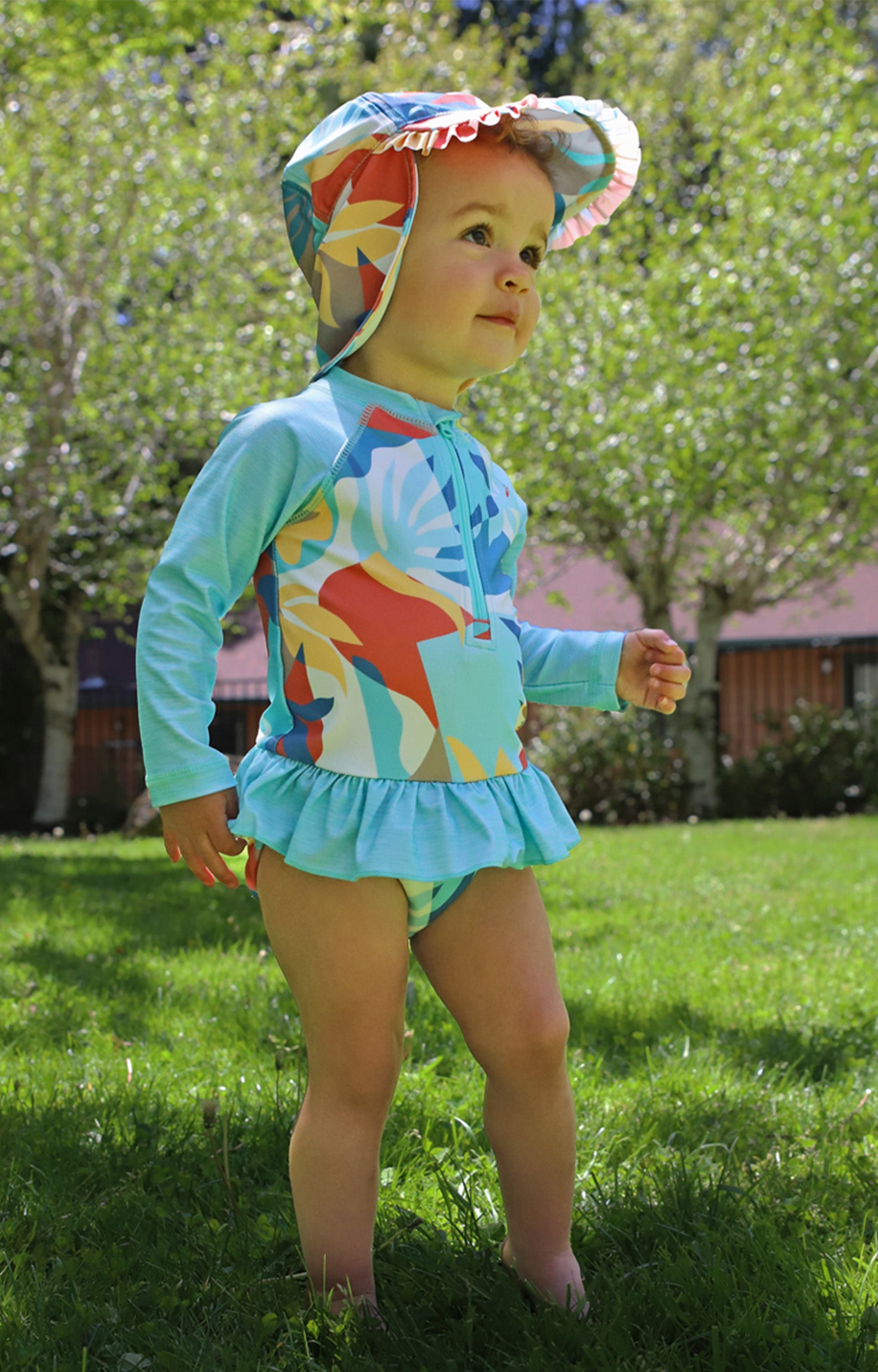 baby girl in long sleeve ruffled swim suit in beach picasso|beach-picasso