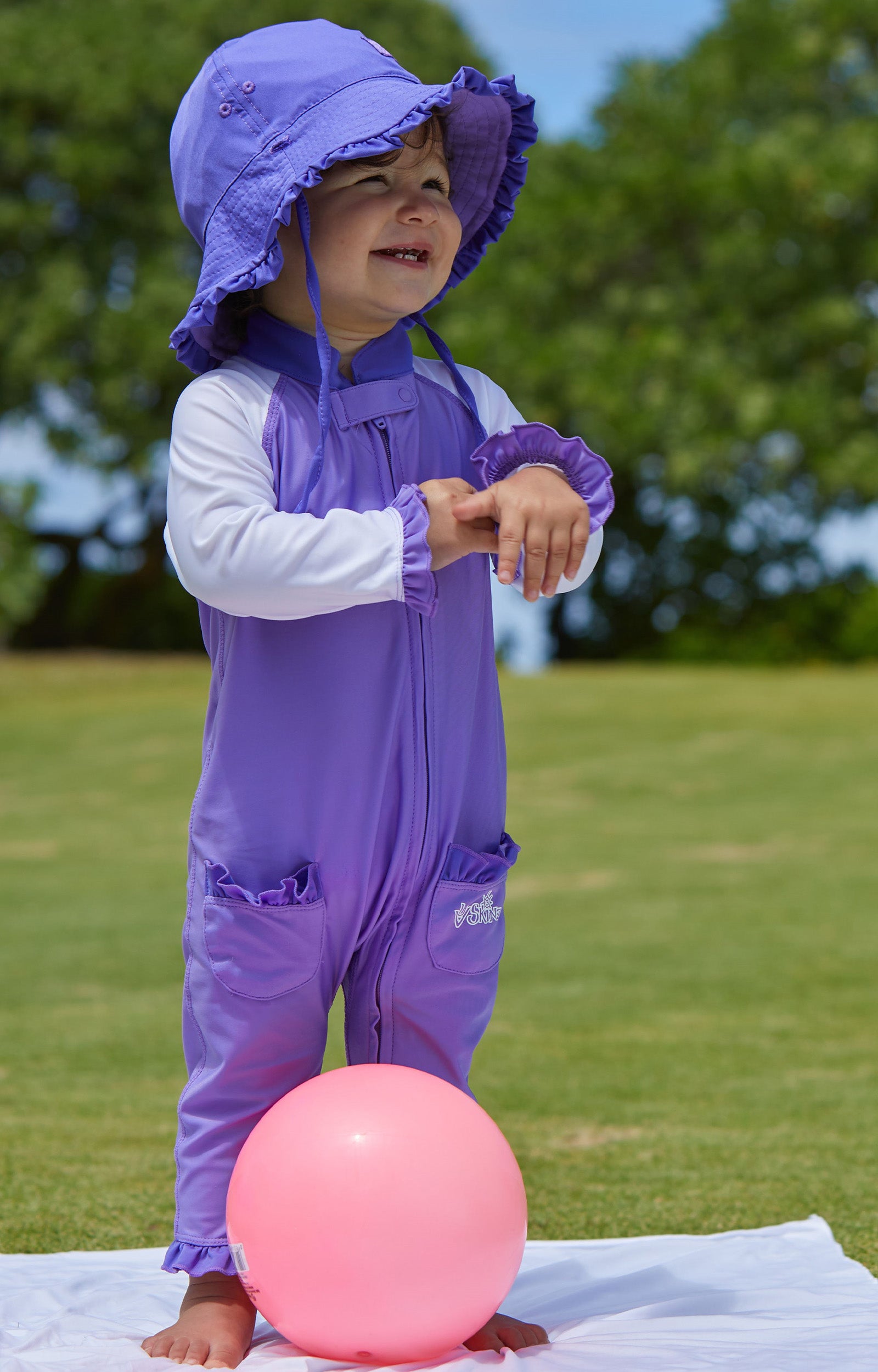 little baby girl in UV Skinz's baby girls long-sleeve swimsuit in misty purple white|misty-purple-white