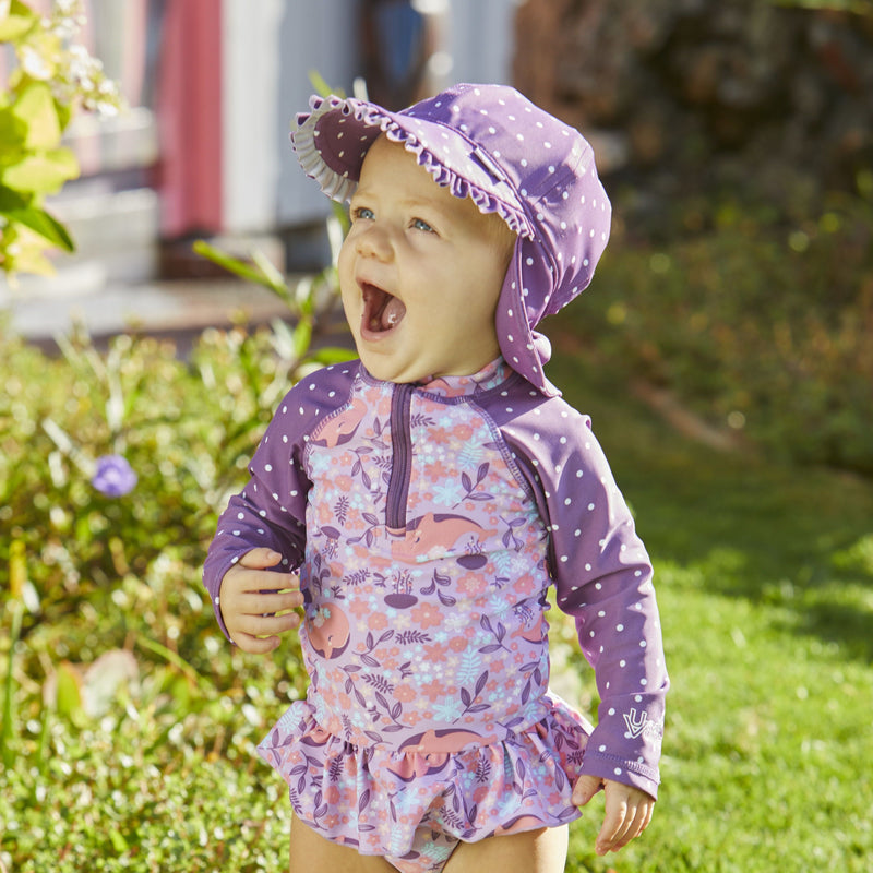 Baby girl in UV Skinz's girls swim flap hat in mulberry dot|mulberry-dot