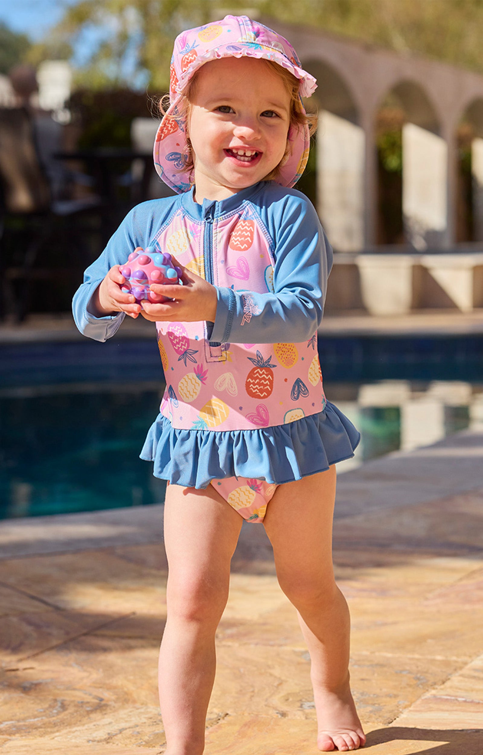 baby girl by pool in swim flap hat|pineapple-party