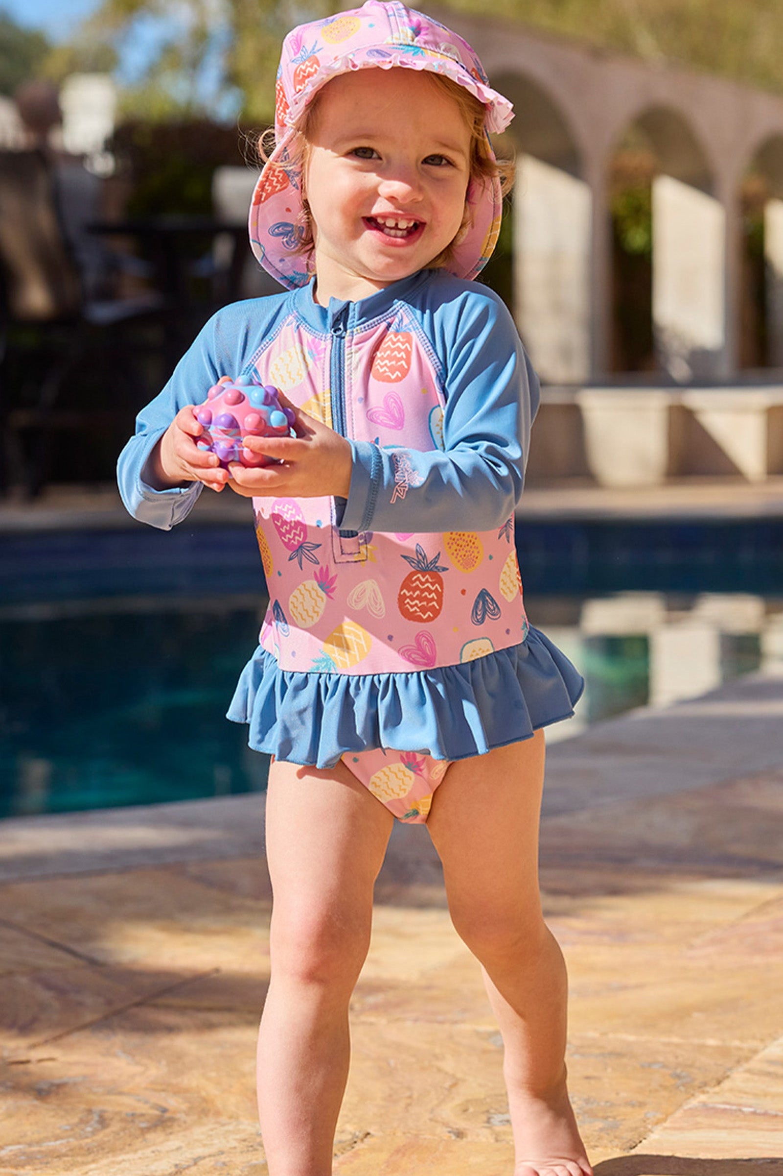 baby girl by pool in swim flap hat|pineapple-party