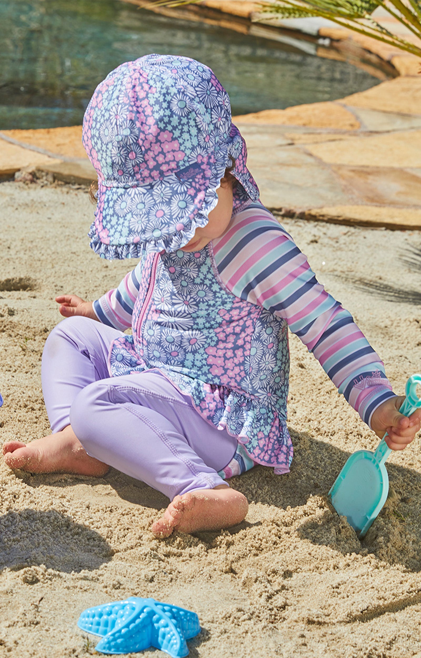 Baby girl playing in UV Skinz's baby girl's swim flap hat|daisy-field