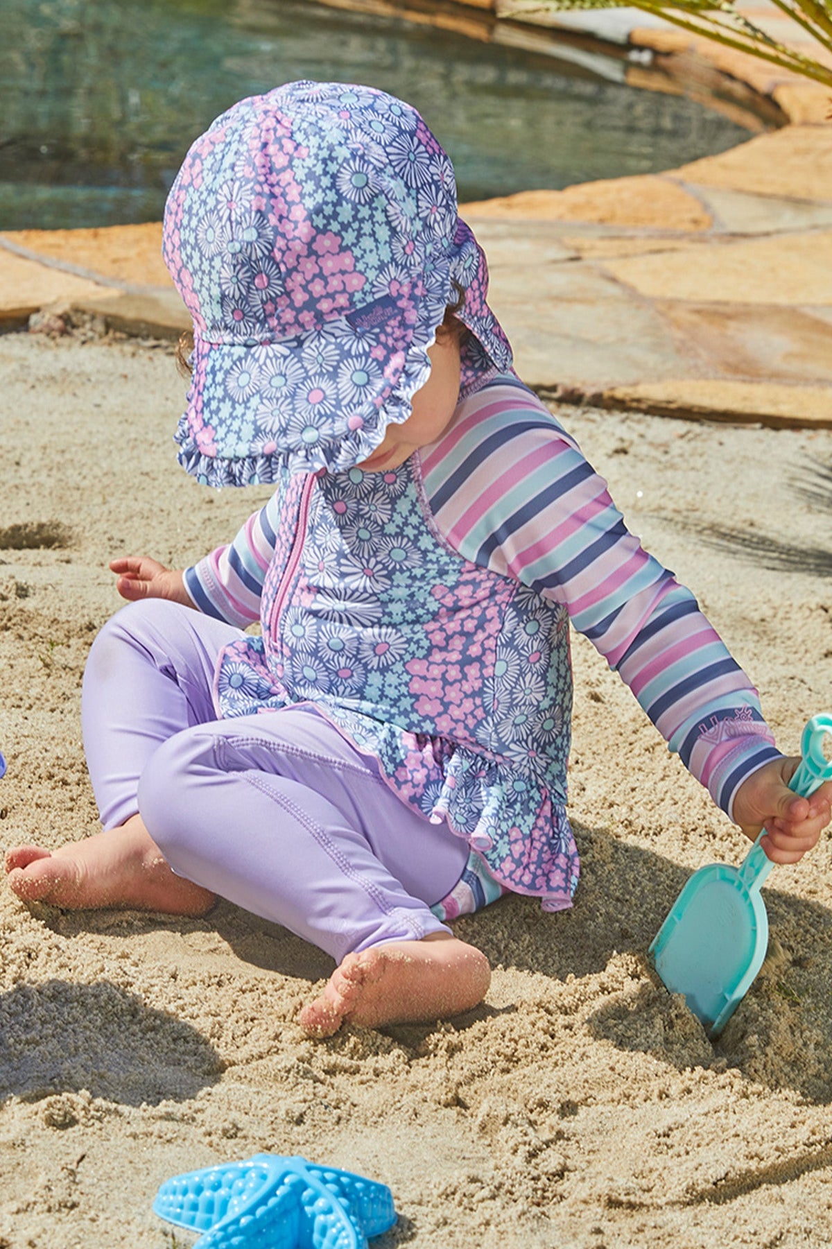 Baby girl playing in UV Skinz's baby girl's swim flap hat