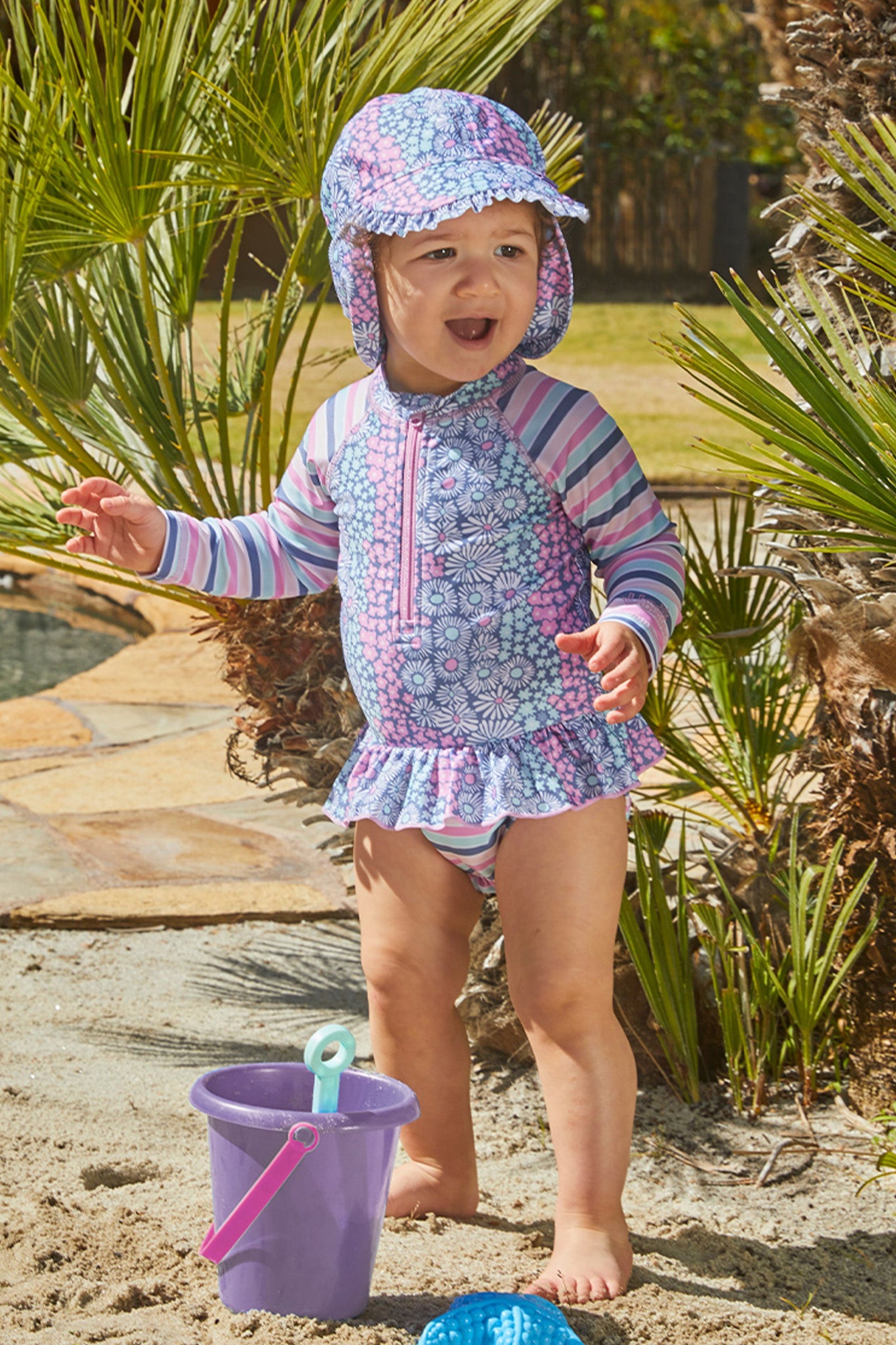 Baby girl in UV Skinz's baby girl's swim flap hat in wandering flowers|wandering-flowers