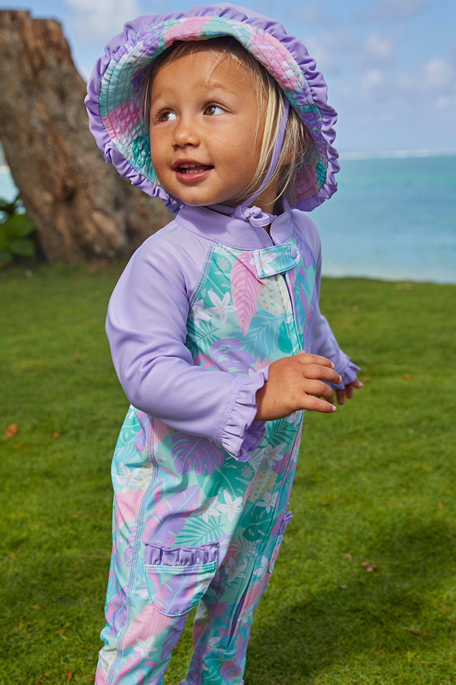 Little girl wearing UV Skinz's baby girl's reversible sun hat in hidden pineapples|hidden-pineapples