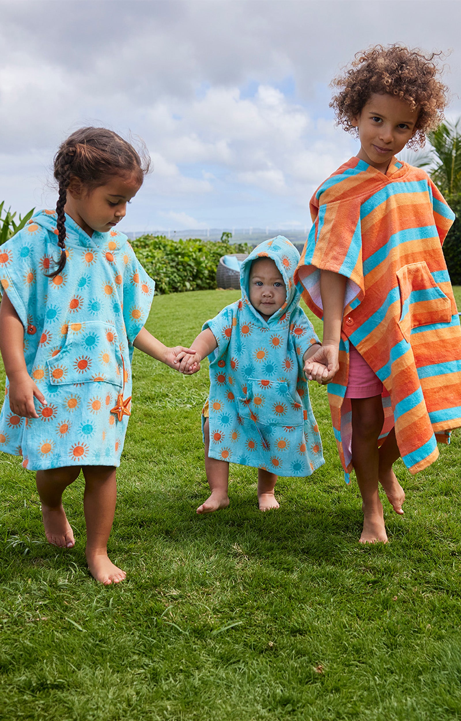 kid's in hooded beach poncho running on grass|sunny-days
