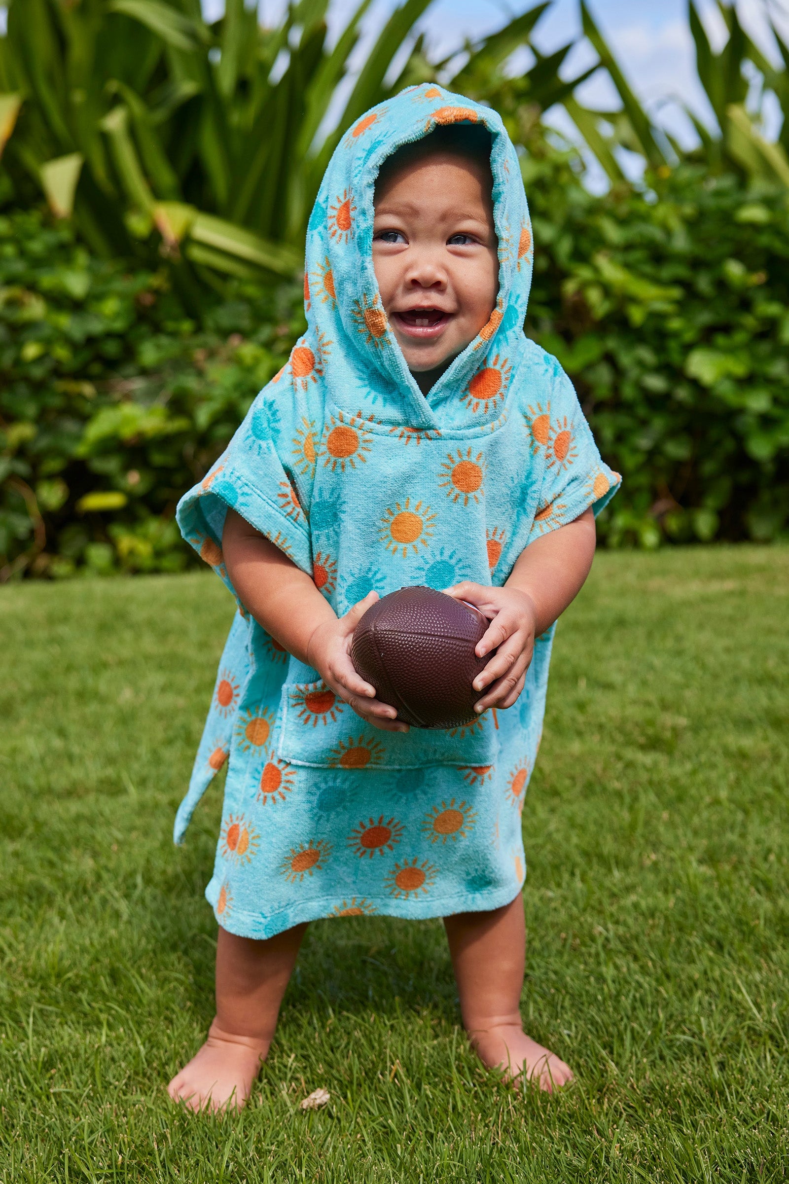 baby with football in hooded beach poncho|sunny-days