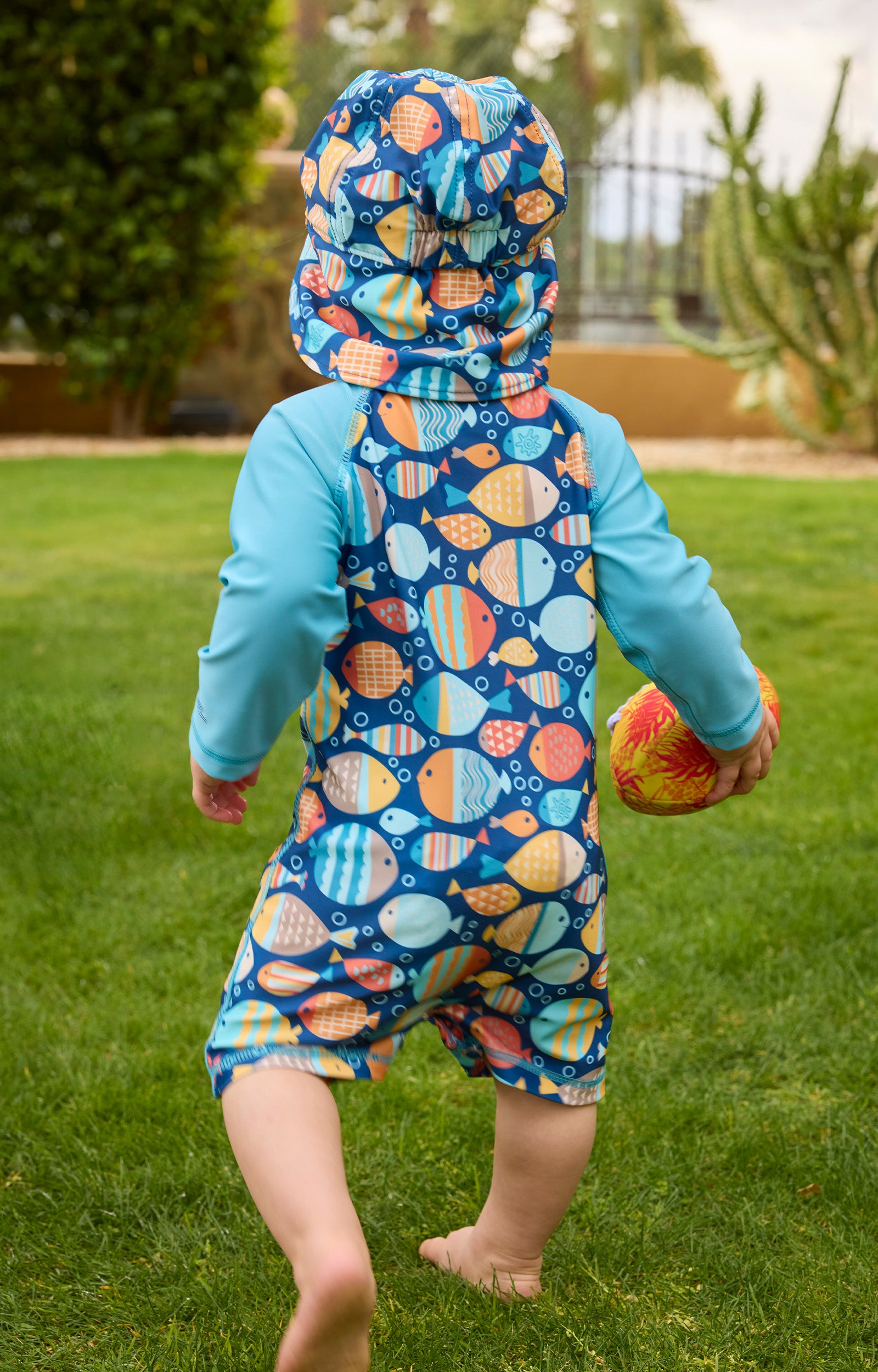 baby boy running in long sleeve swim romper in grass|fish-parade