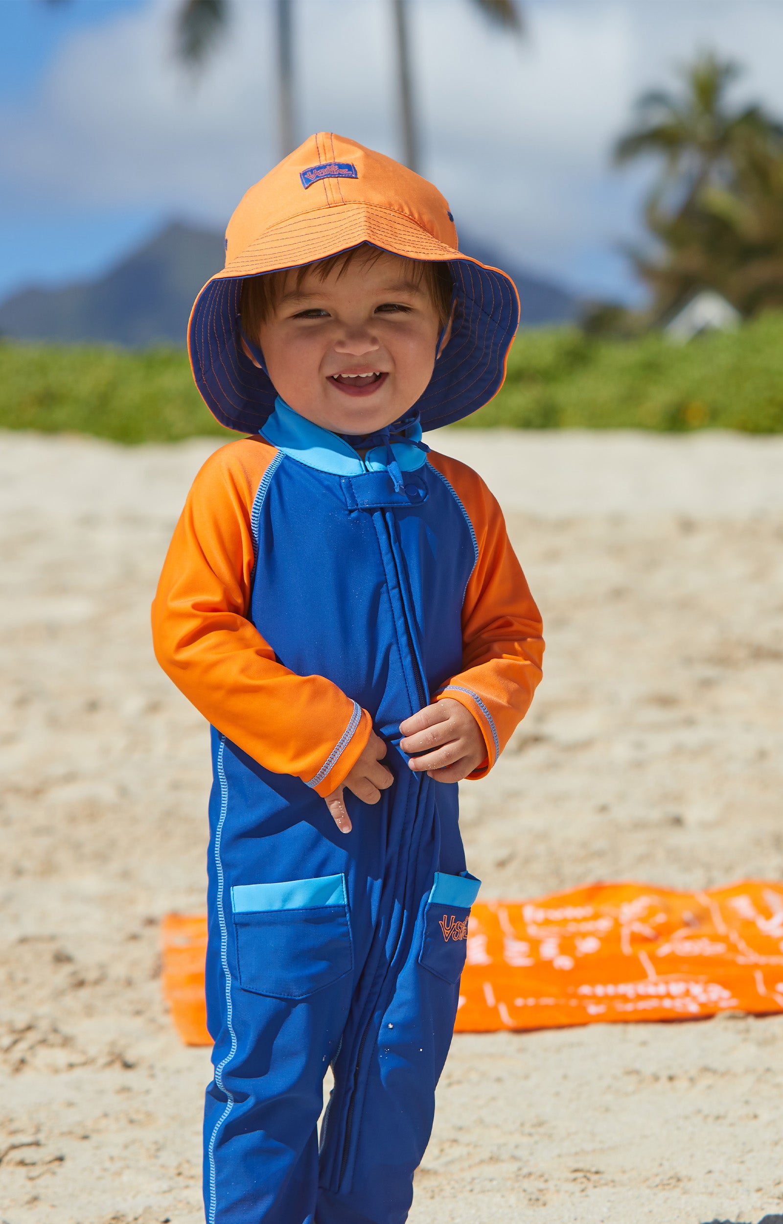 Little boy in UV Skinz's baby boy's sun hat in navy blue orange|navy-blue-orange
