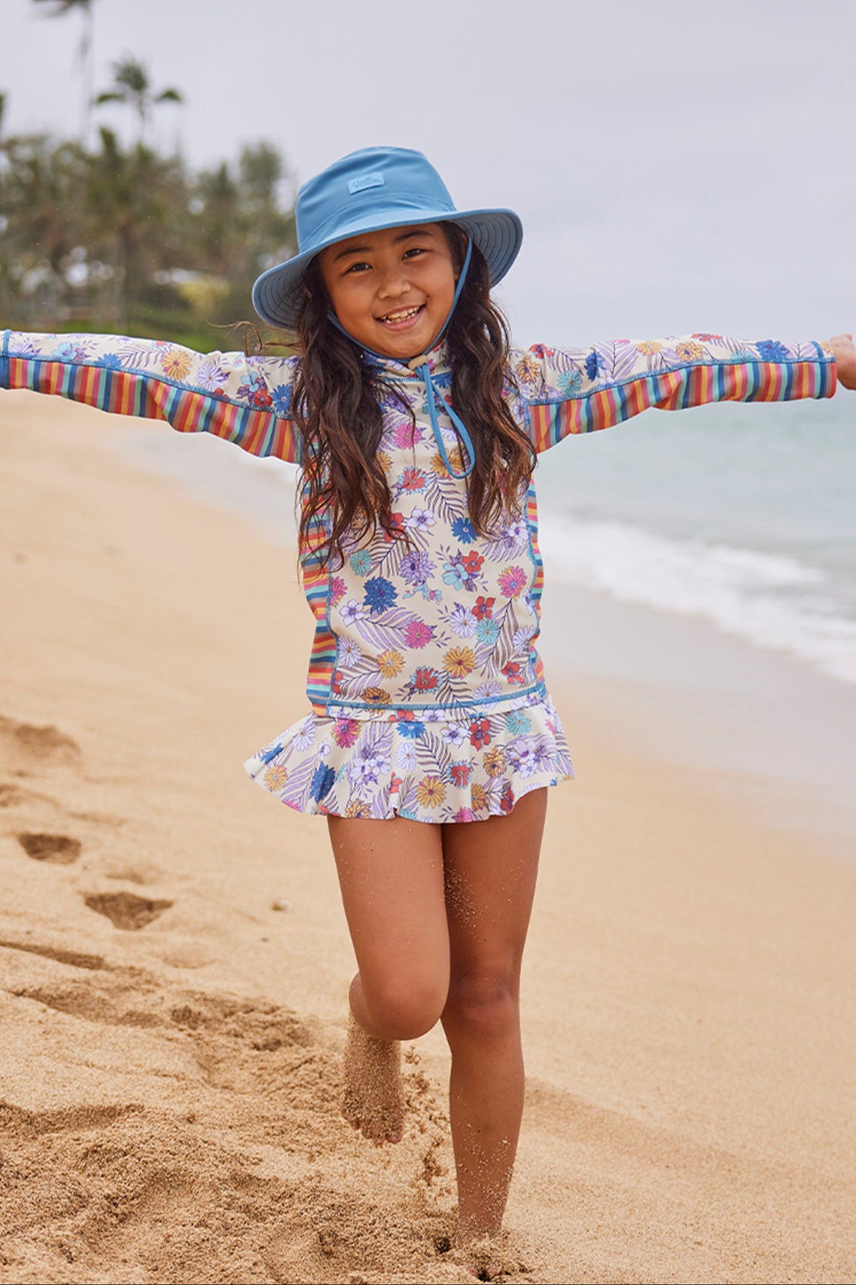 girl running on beach in swim hat|baltic