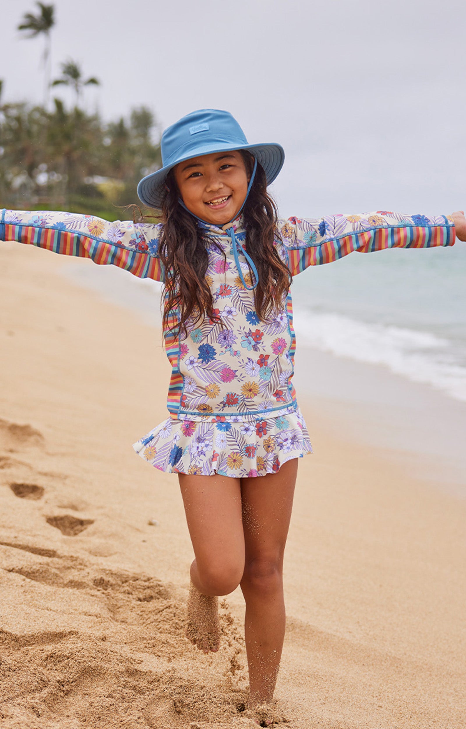 girl running on beach in swim hat|baltic