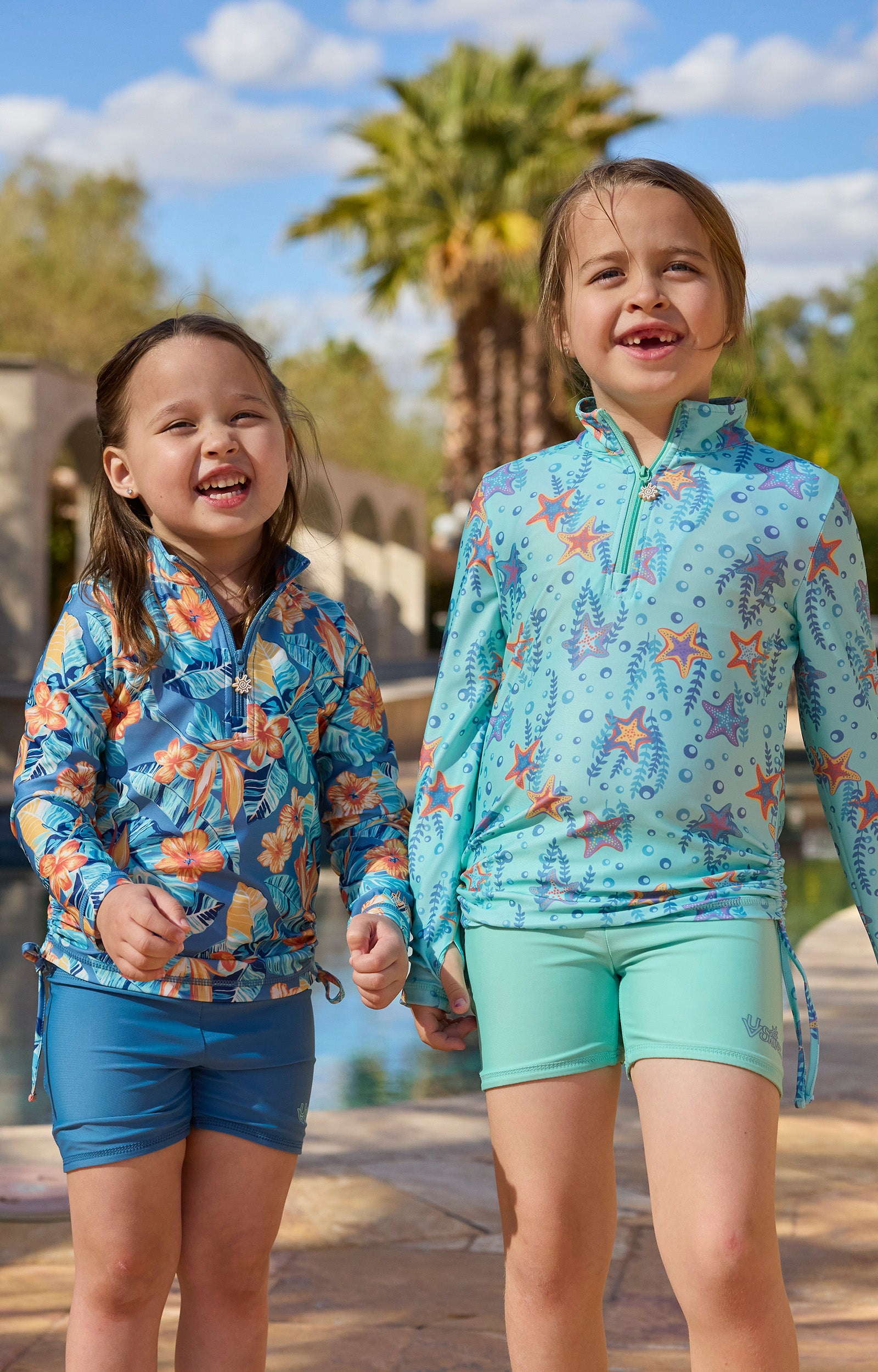 girls laughing by pool in reversible active swim shorts|maui-hibiscus-baltic