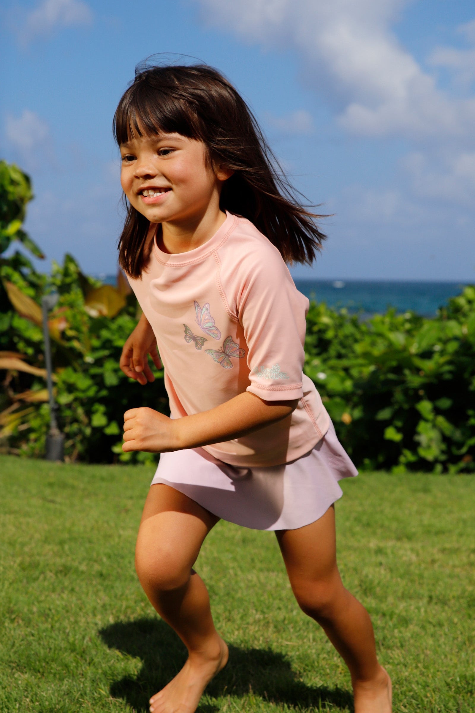 girl running in kids short sleeve crew sunny swim shirt in butterfly besties|butterfly-besties