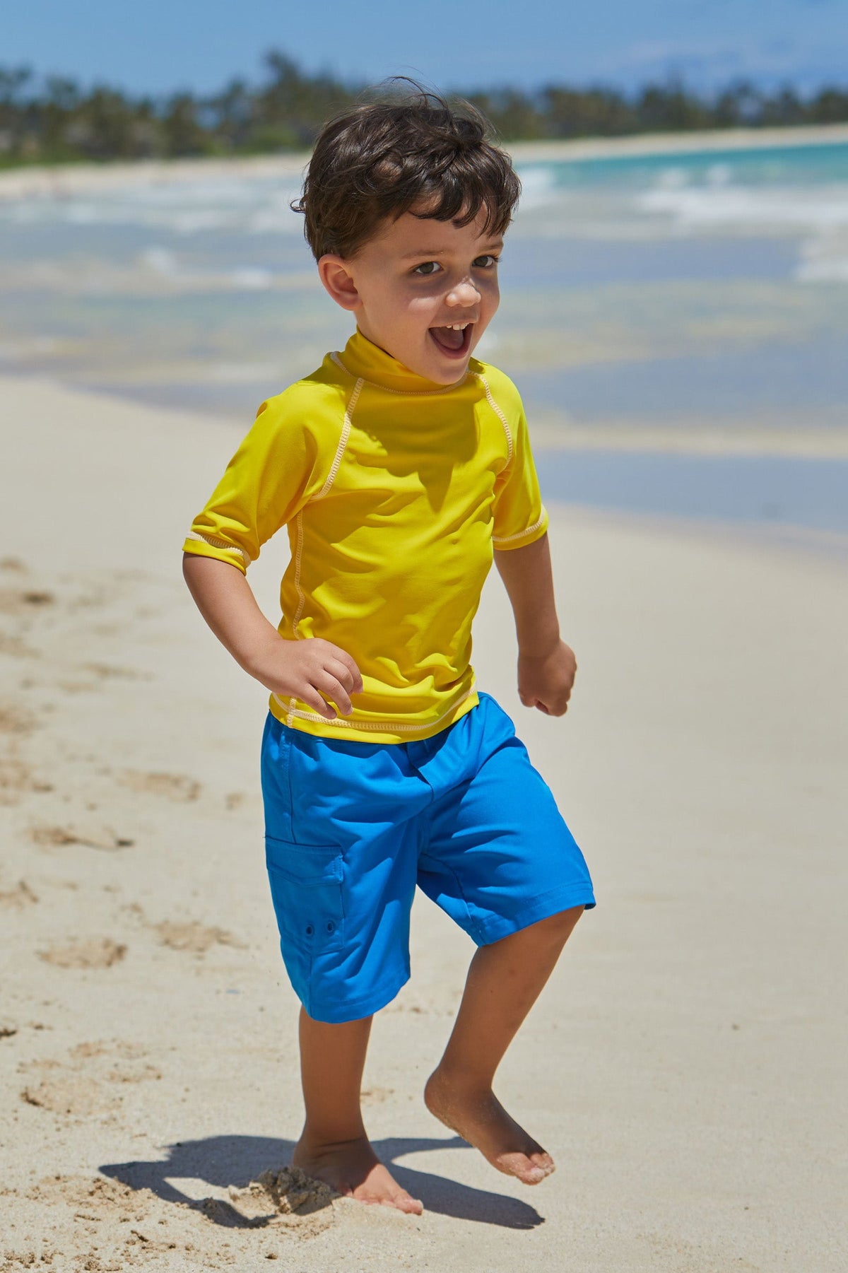 Little boy in UV Skinz's kid's short sleeve swim shirt in cyber yellow|cyber-yellow