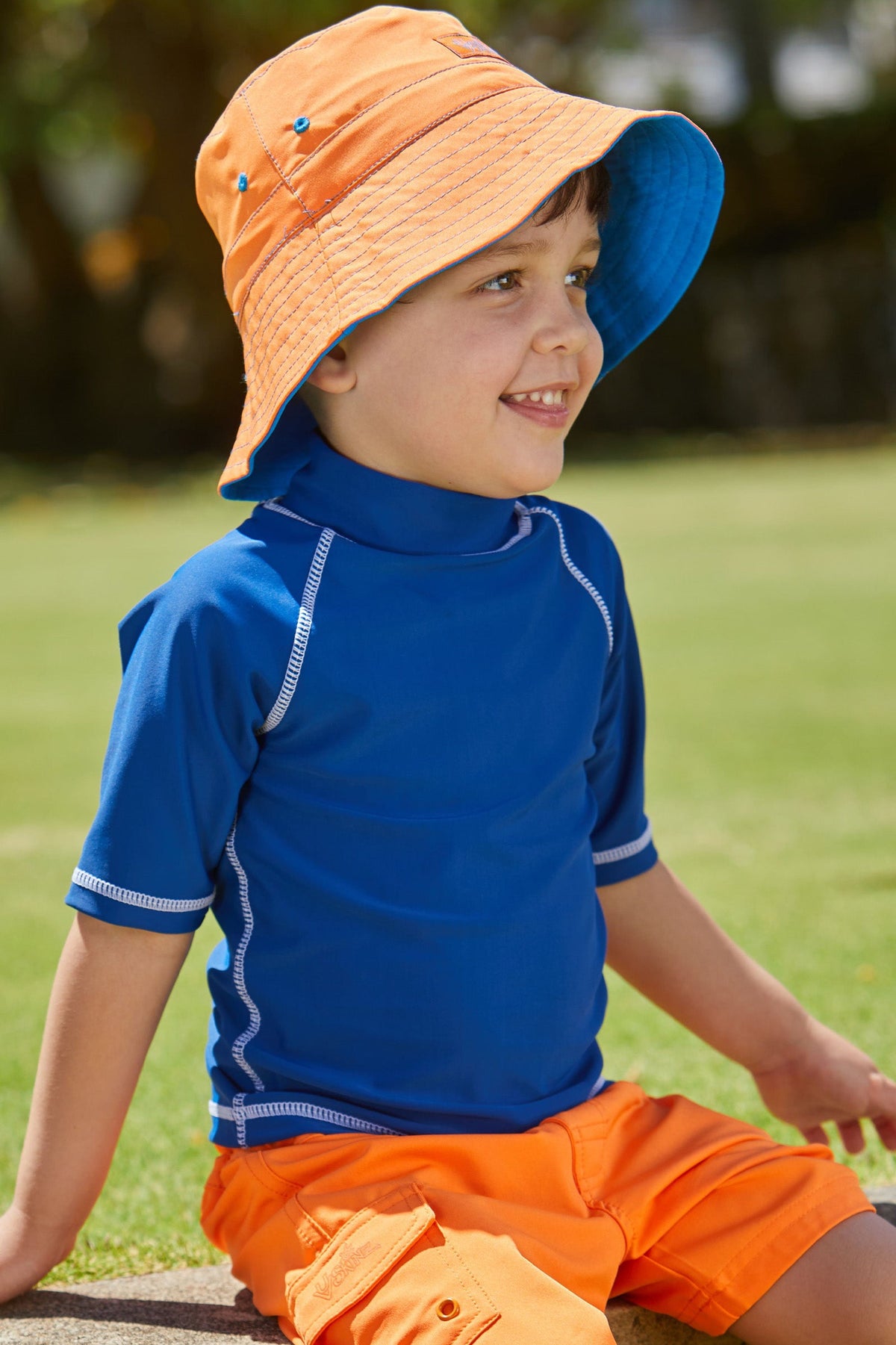 Boy wearing the boy's bucket hat in royal orange