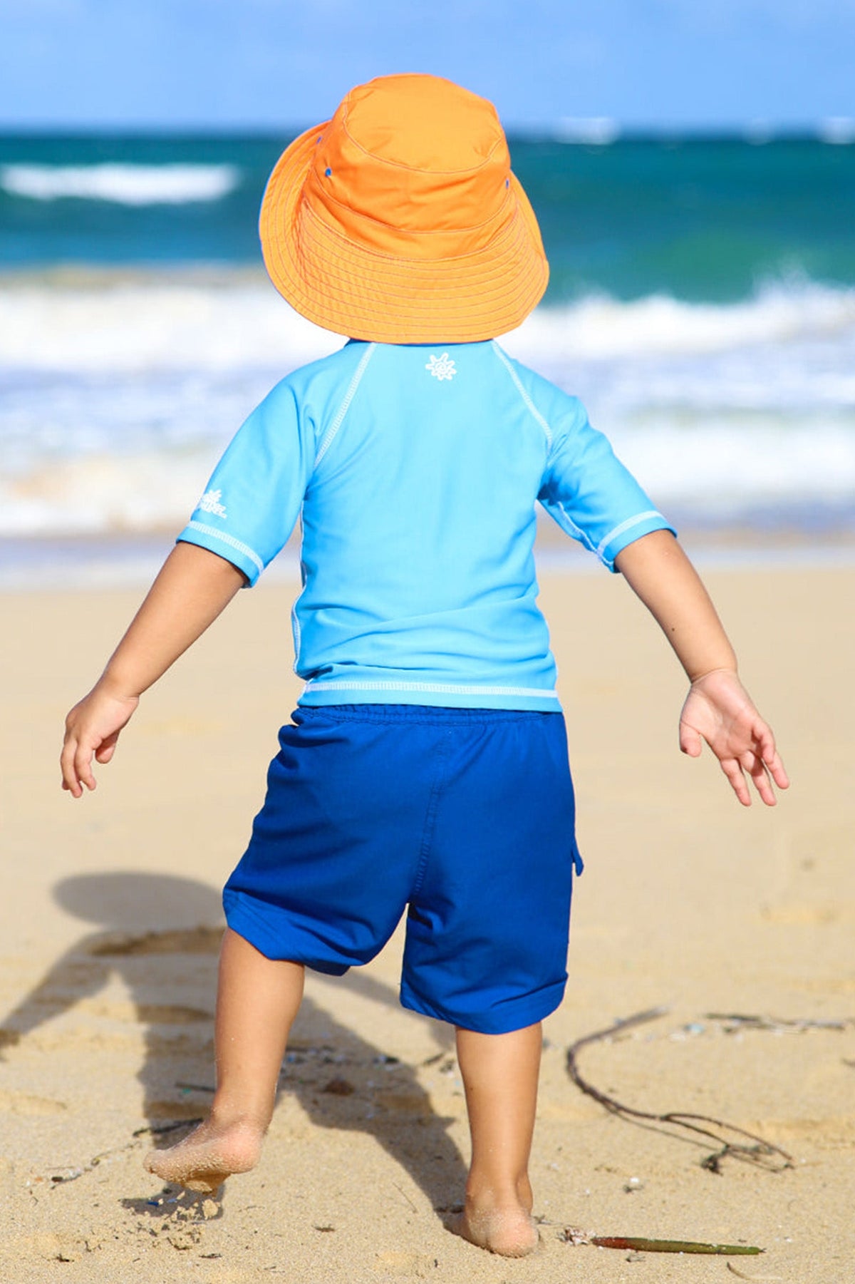 Little boy wearing the boy's bucket hat in royal orange