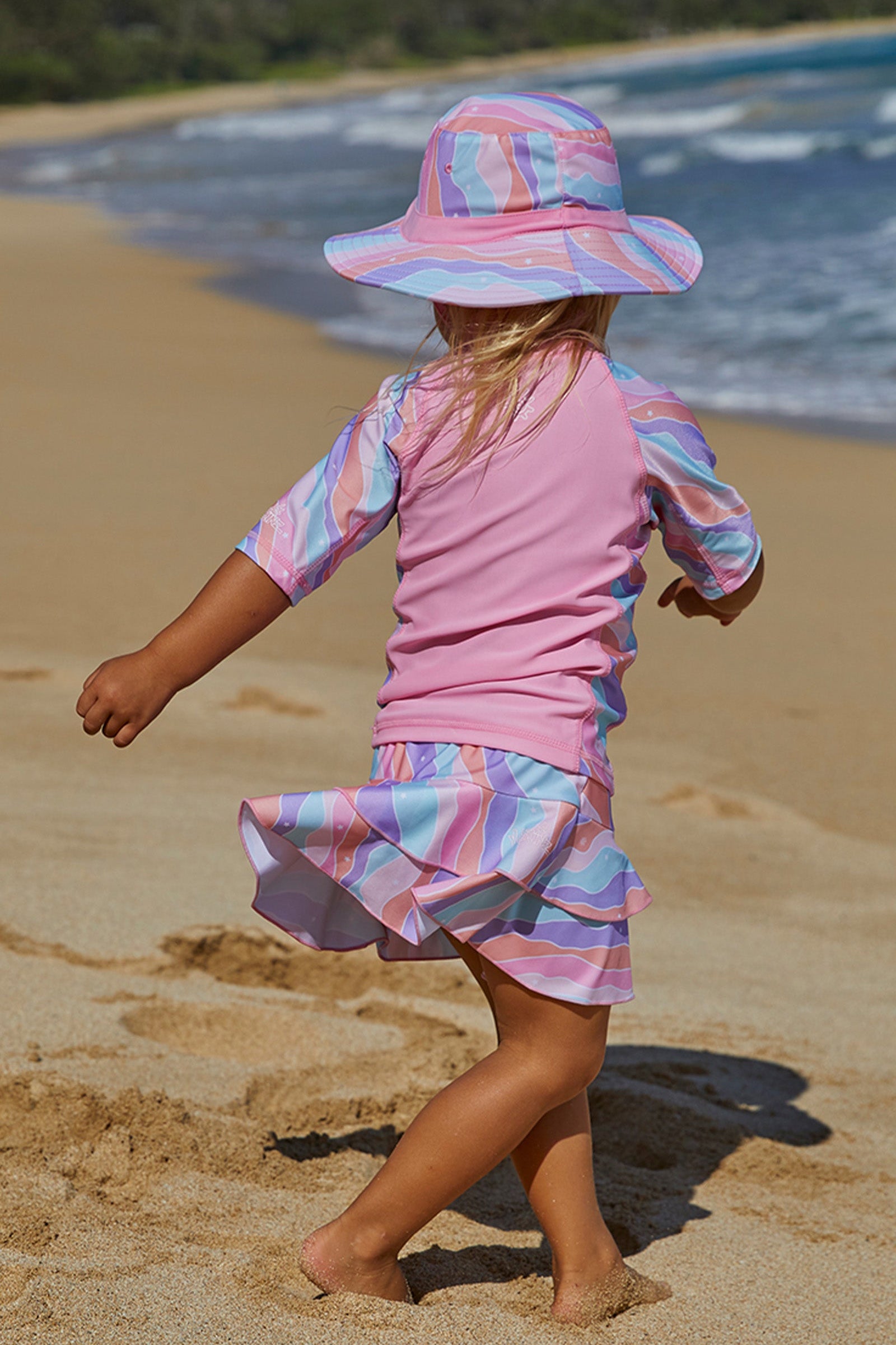 Little girl playing in UV Skinz's girls swim skirt in rollin along|rollin-along