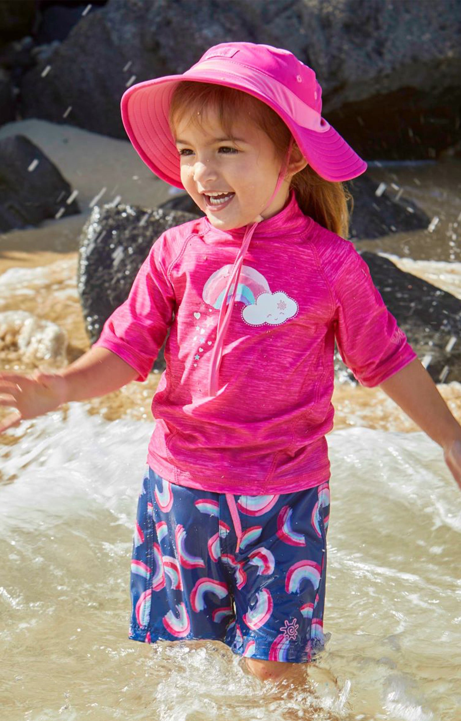 Little girl in UV Skinz's girl's short sleeve sport sun and swim shirt in hot pink jaspe rainbow|hot-pink-jaspe-rainbow