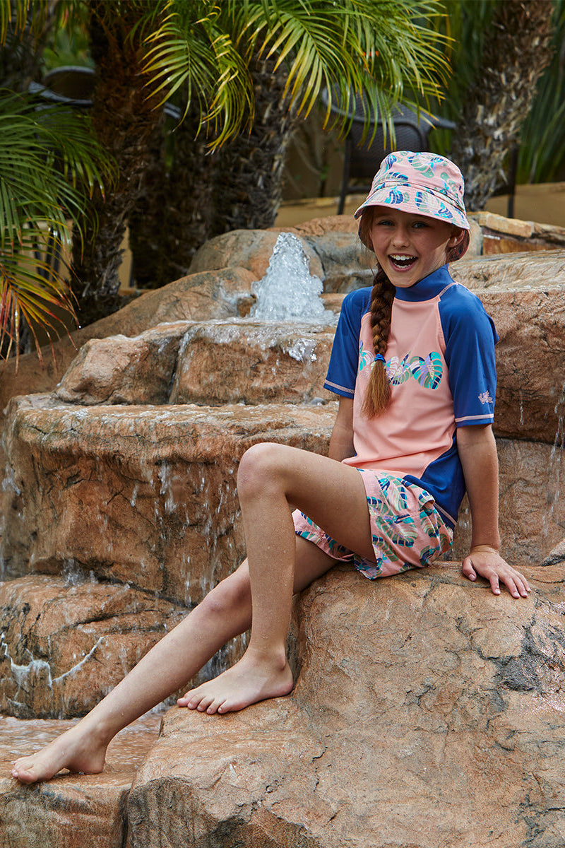 Young girl in UV Skinz's girl's short sleeve sport sun and swim shirt in rainbow vibes|rainbow-vibes