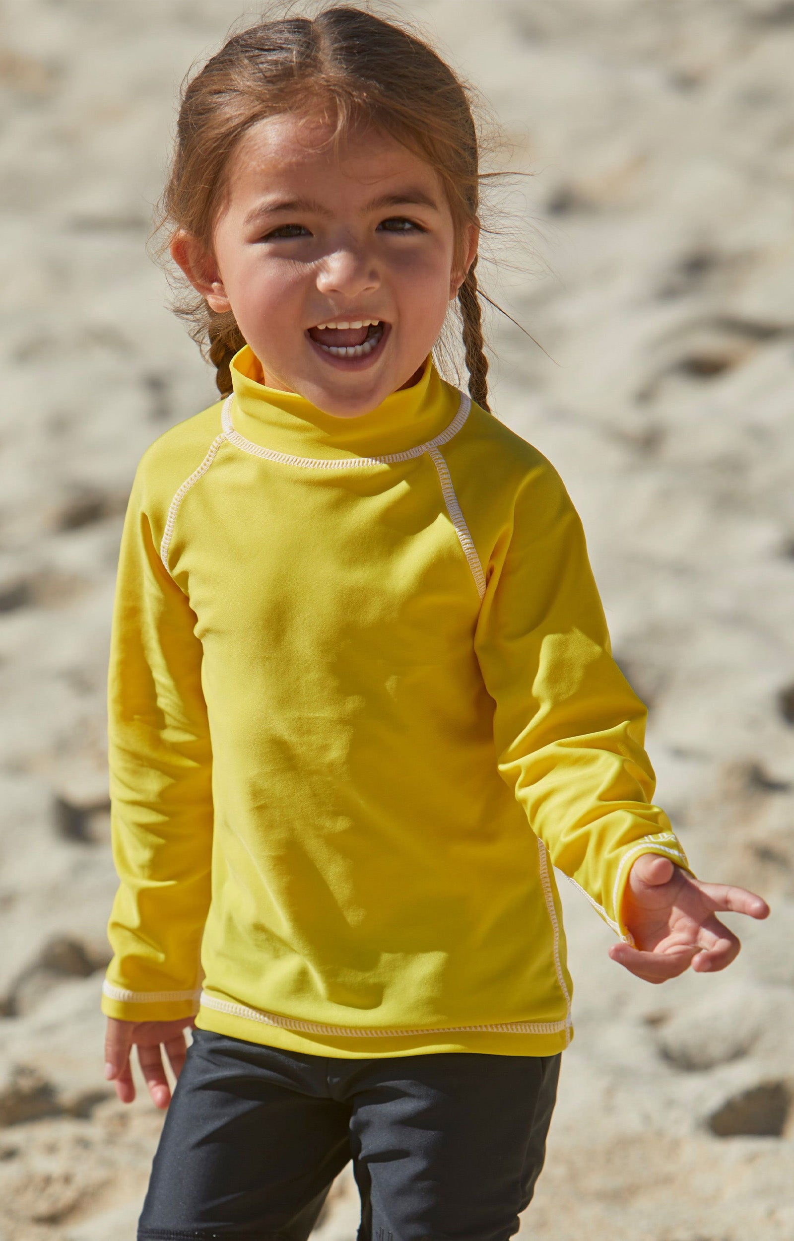 Little girl playing on the beach in kid's long sleeve swim shirt in cyber yellow|cyber-yellow