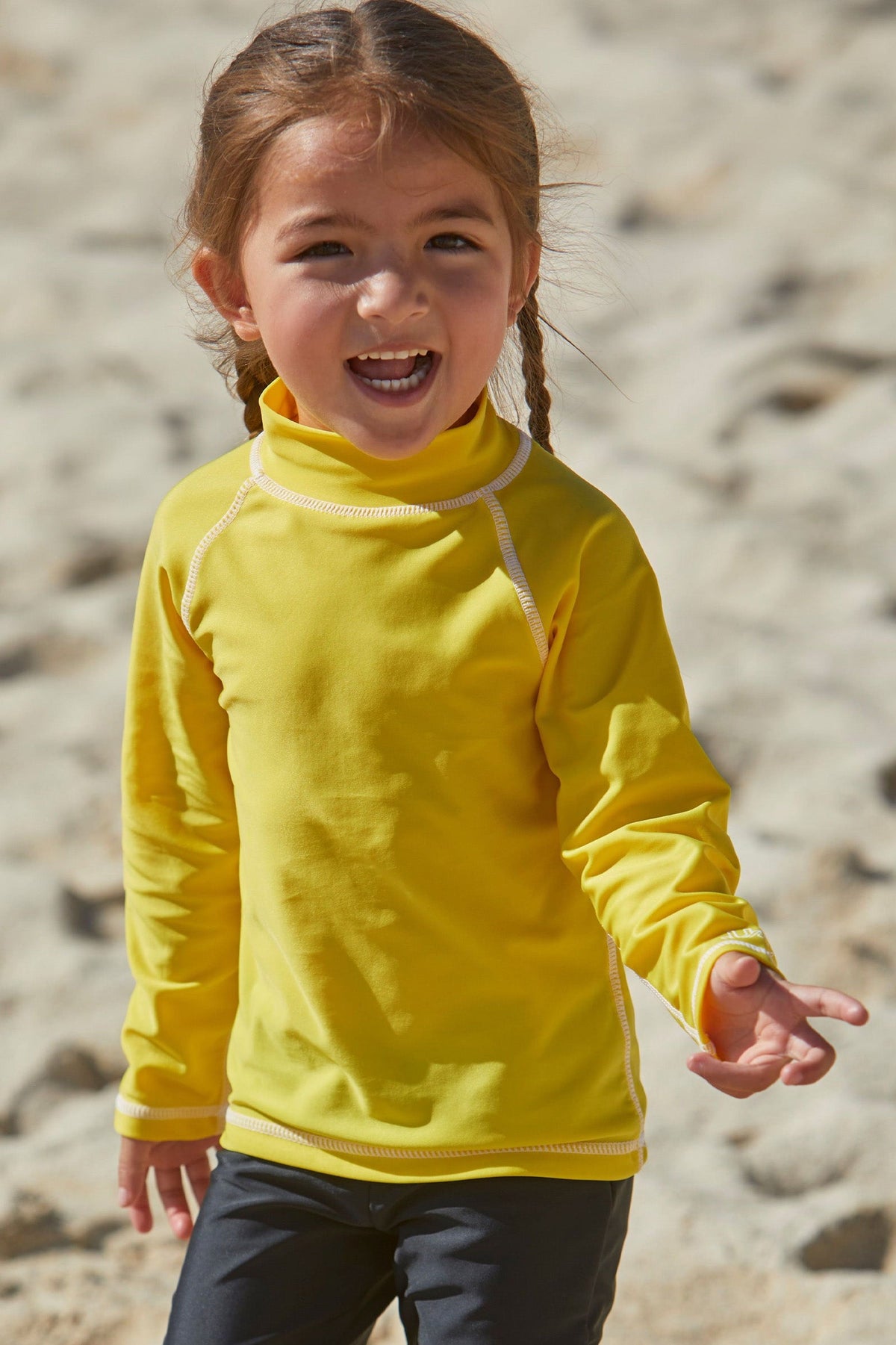 Little girl playing on the beach in kid's long sleeve swim shirt in cyber yellow|cyber-yellow