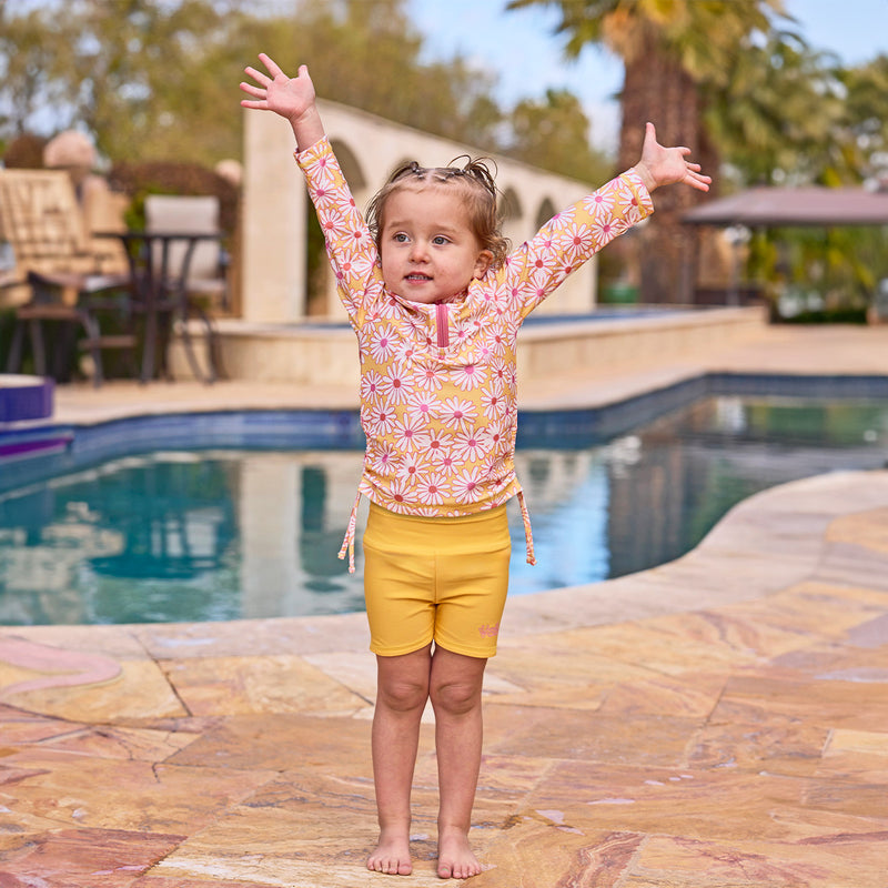 girl with arms up by pool in half zip ruched sun & swim shirt|sunshine-daisies