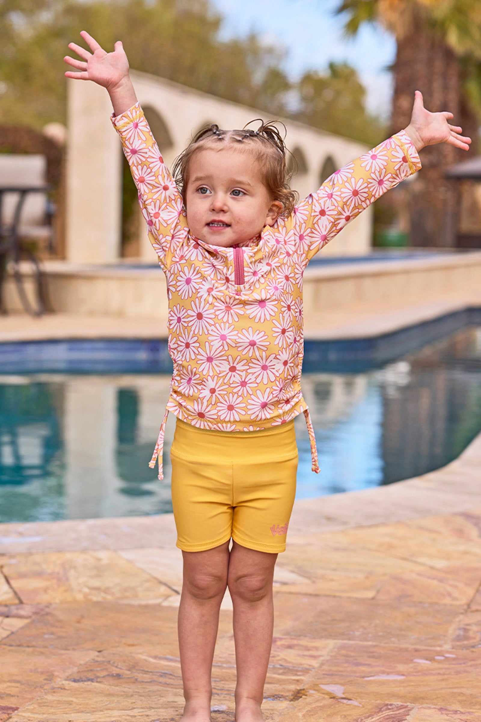 girl with arms up by pool in half zip ruched sun & swim shirt|sunshine-daisies