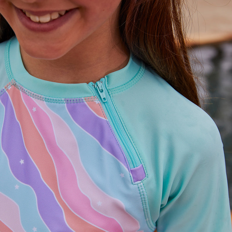 Close up of the zipper on the girl's long sleeve swim shirt in rollin along|rollin-along
