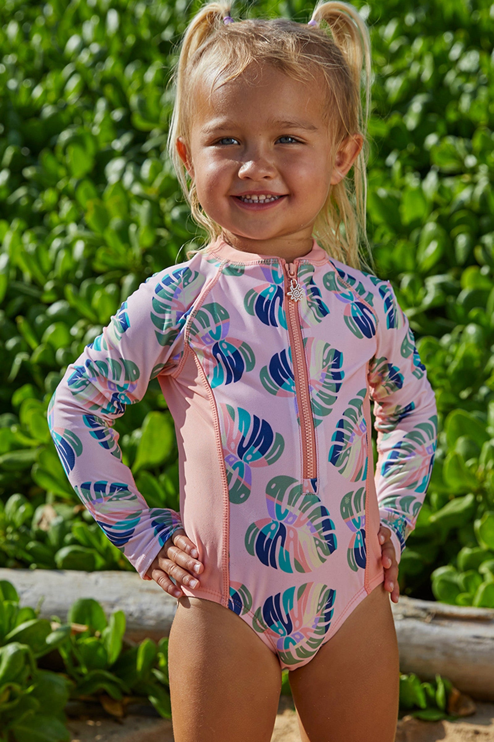 Little girl in UV Skinz's girl's long sleeve swimsuit in rainbow leaf|rainbow-leaf
