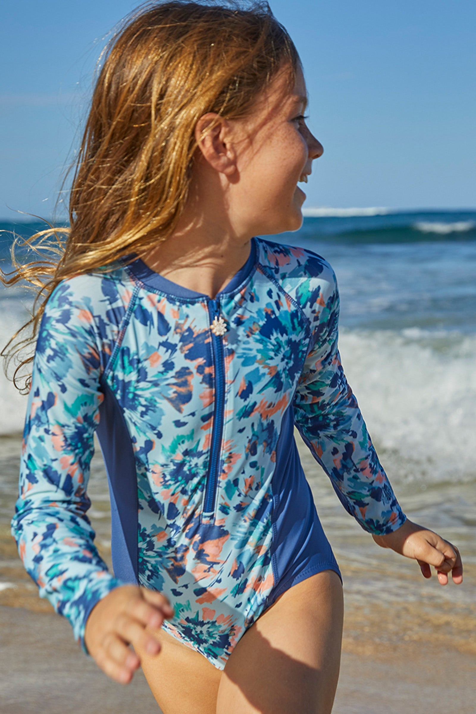 Young girl in UV Skinz's girl's long sleeve swimsuit in yosemite tie dye|yosemite-tie-dye