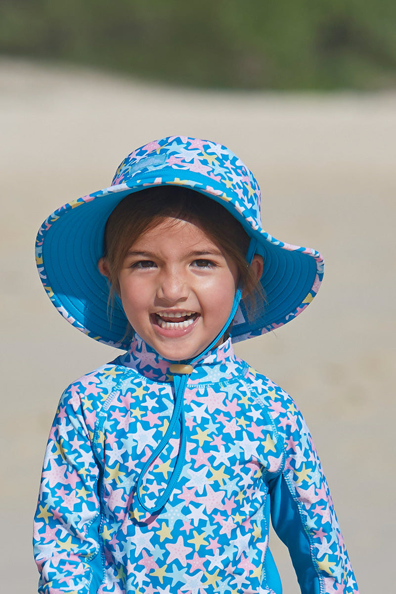 Little girl wearing UV Skinz's girl's swim hat in starfish party|starfish-party