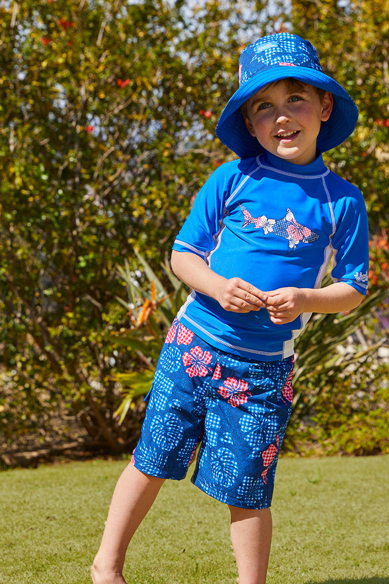 Little Boy in UV Skinz's Boy's Classic Board Shorts in Dark Navy Hibiscus|dark-navy-hibiscus