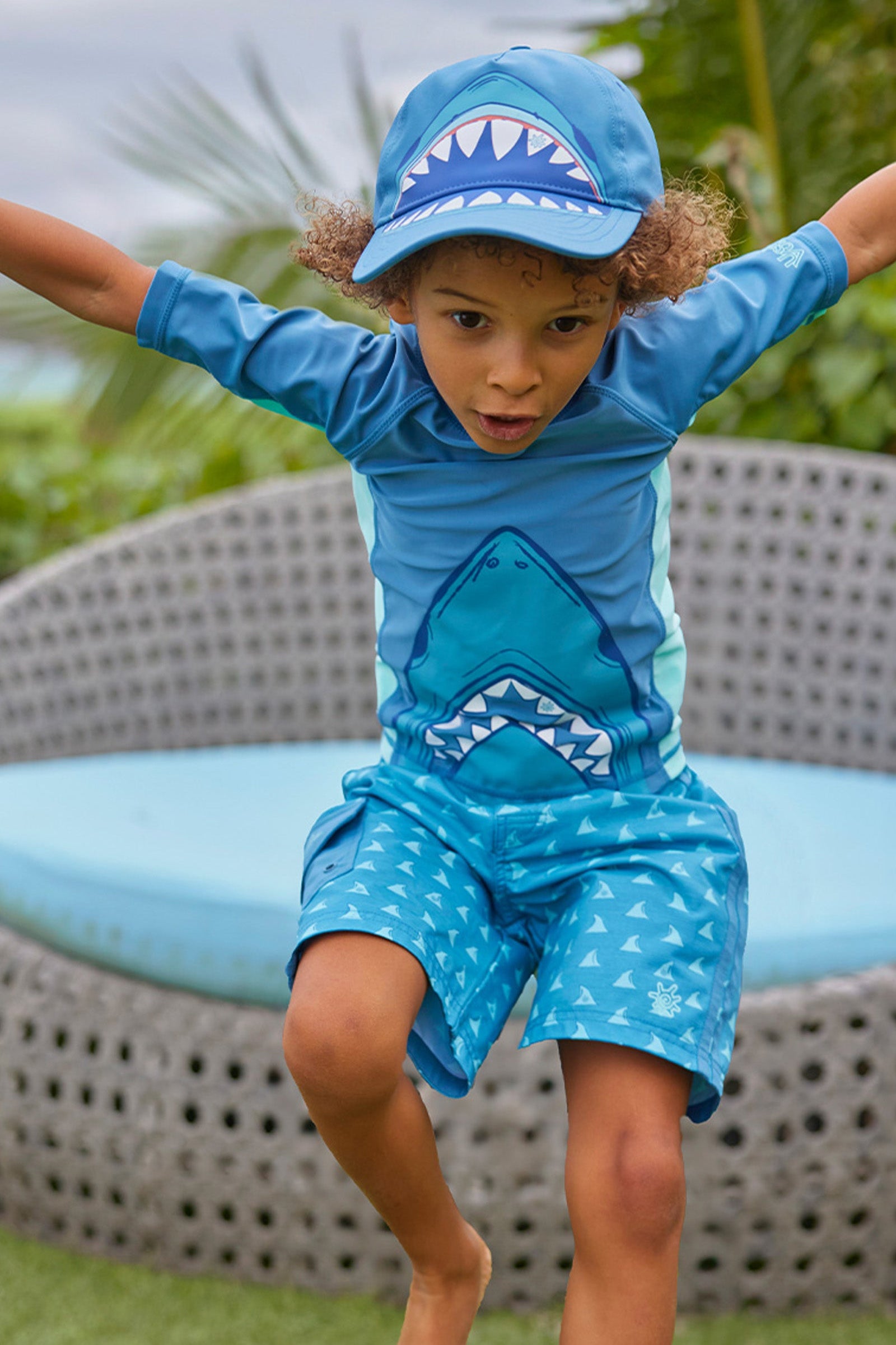 boy jumping in snap back hat|baltic-shark-bite