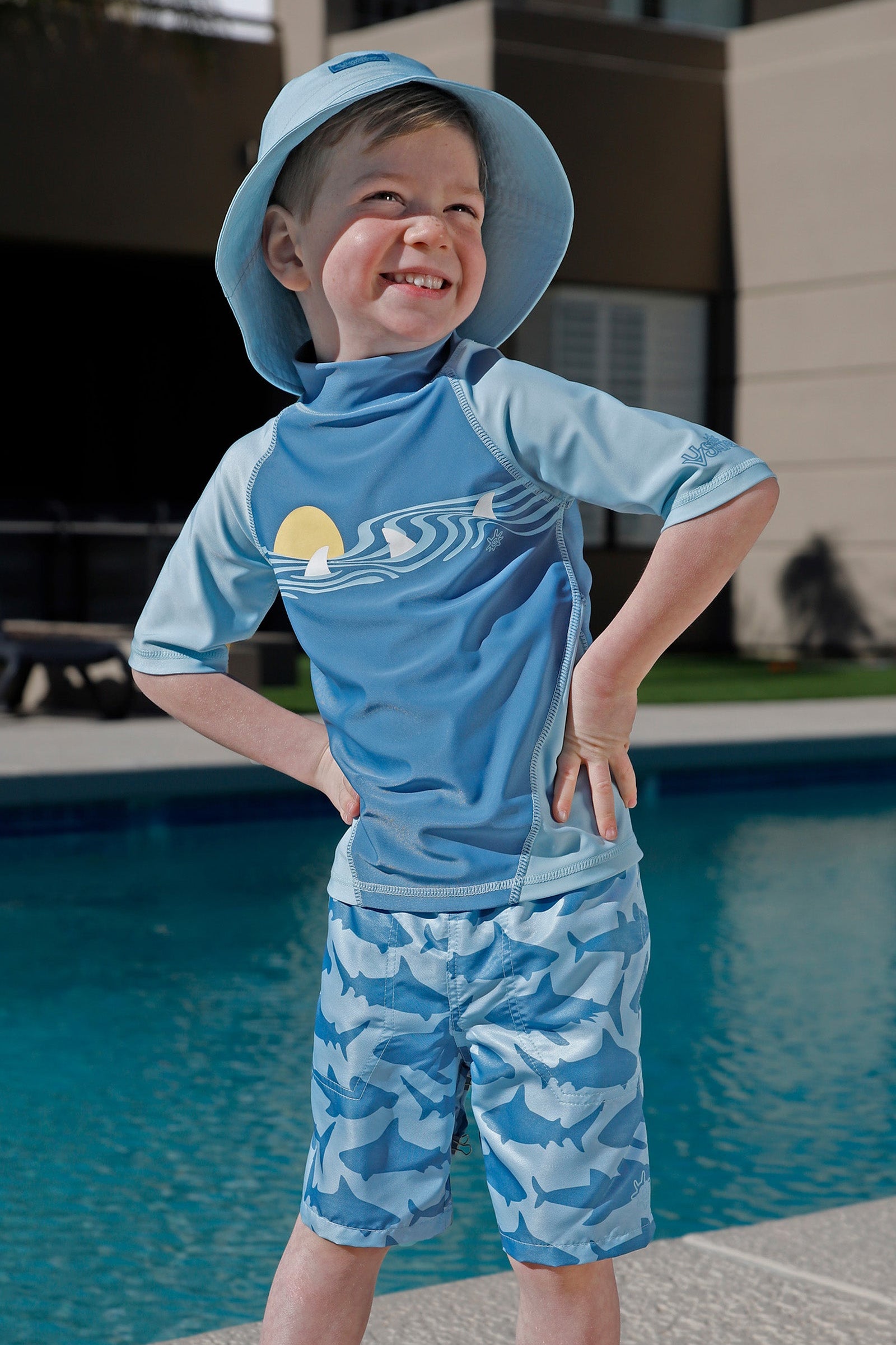 boy by the pool in magic beach shorts|magic-sharks