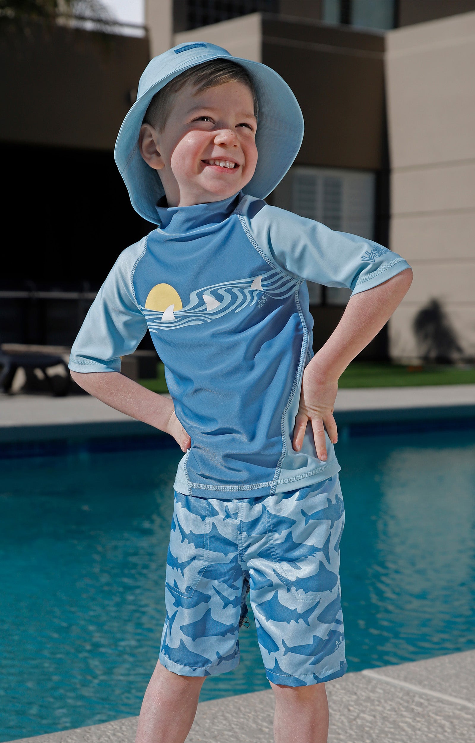 boy by the pool in magic beach shorts|magic-sharks