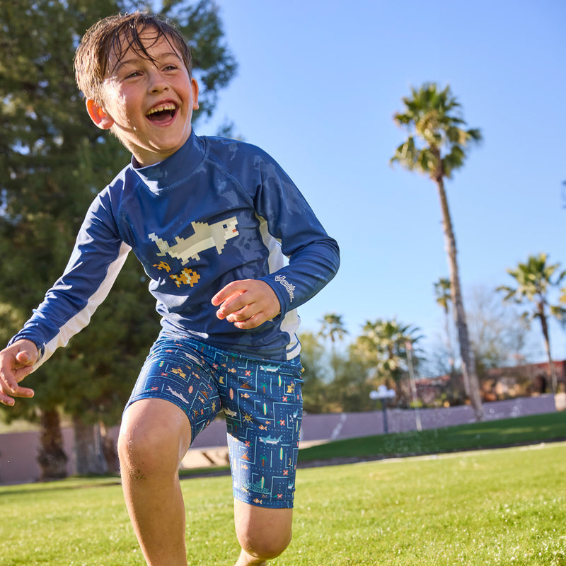 boy running in grass in long sleeve sun swim shirt|shark-cade-game