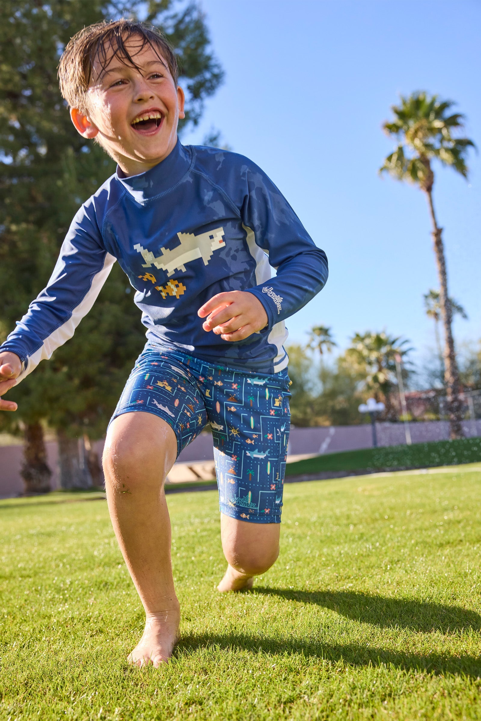 boy running in grass in long sleeve sun swim shirt|shark-cade-game
