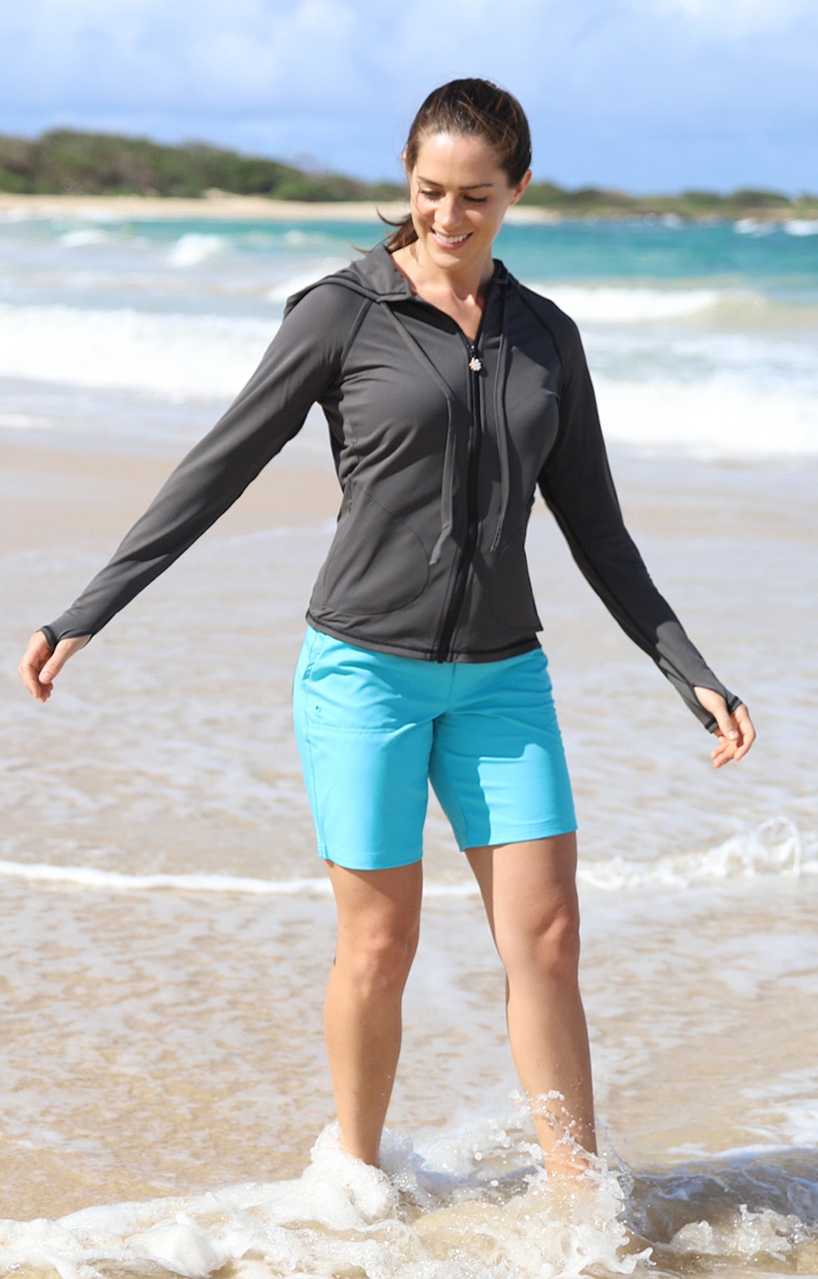 Woman Walking in the Ocean in UV Skinz's Women's Board Shorts in Aqua|aqua