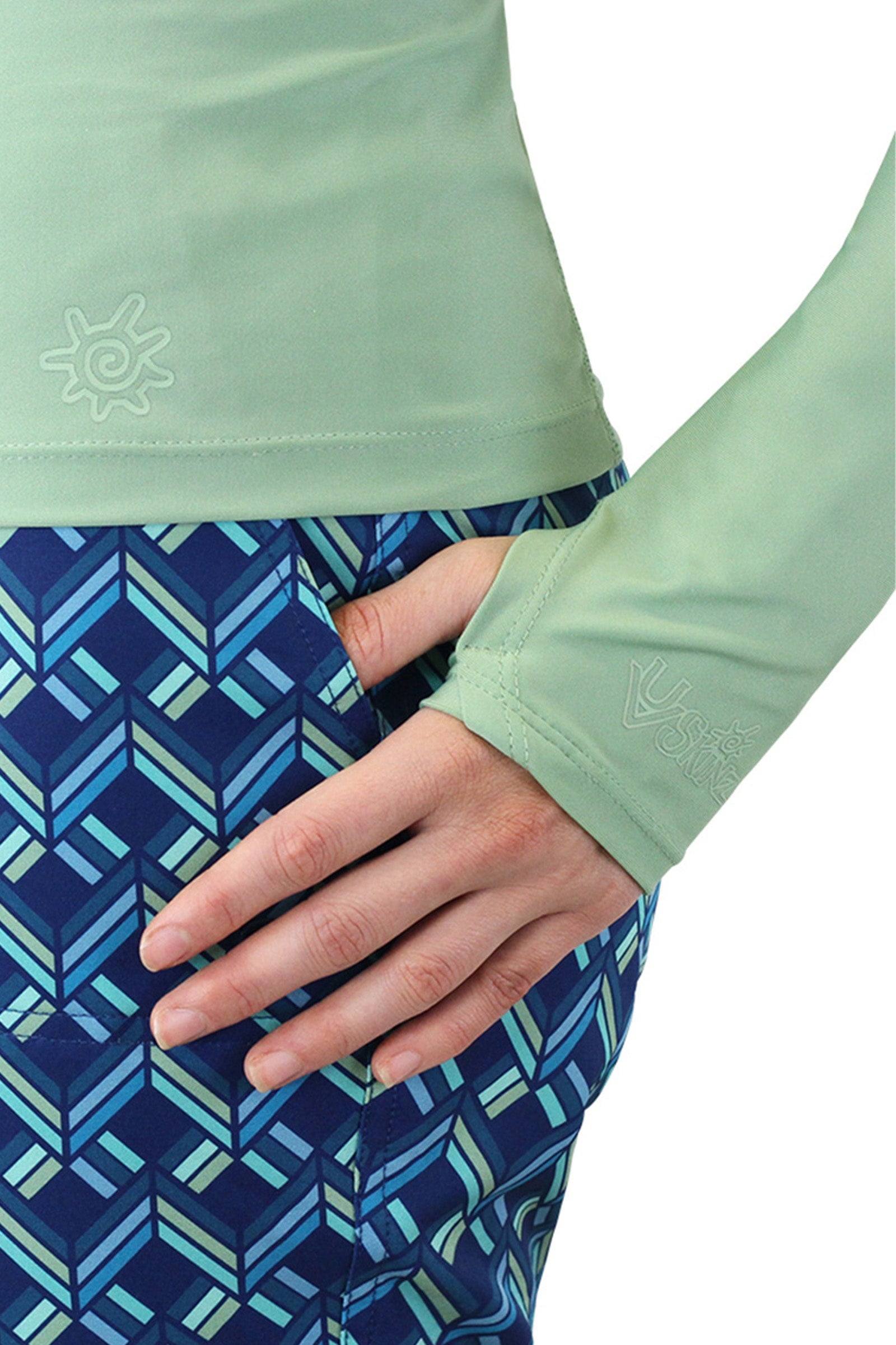 Close up of the thumb holes on the women's long sleeve rash guard in sage|sage