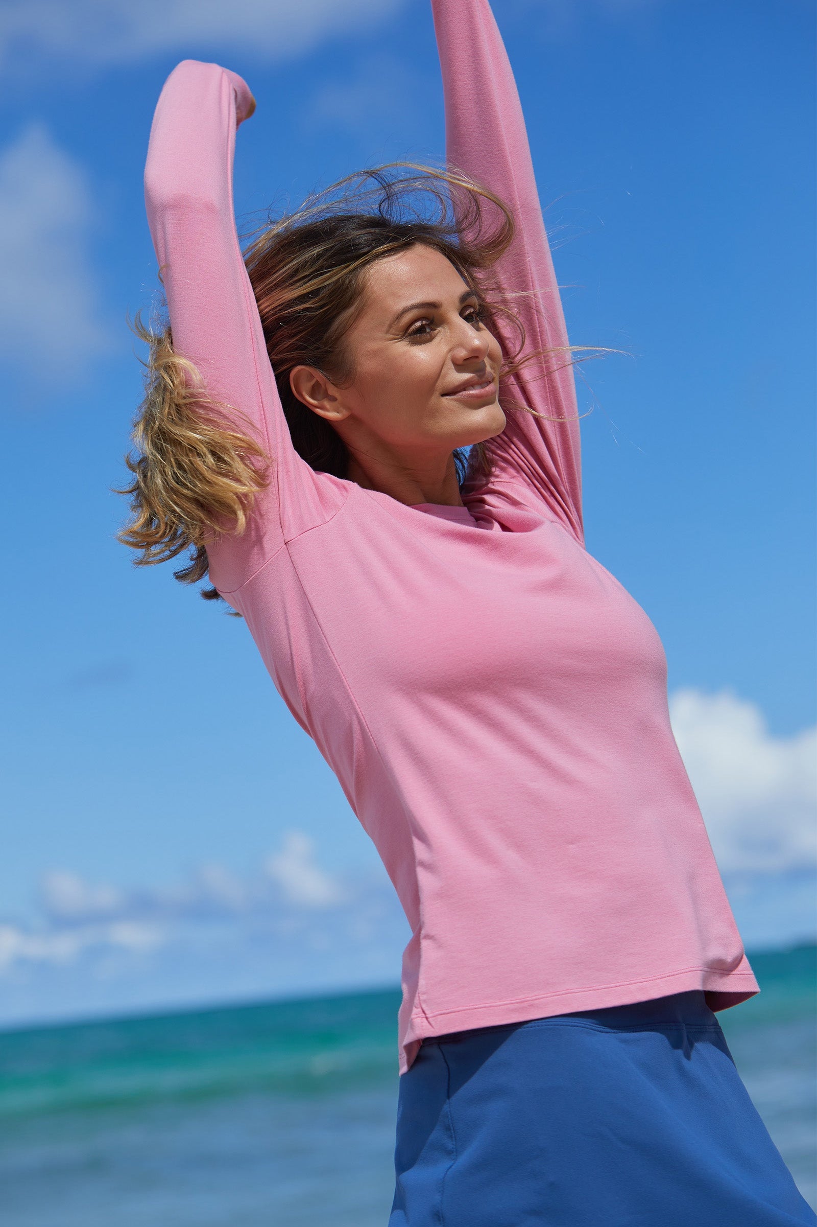 Woman Walking Down the Beach in UV Skinz's Women's Long Sleeve Everyday Tee in Wild Rose|wild-rose