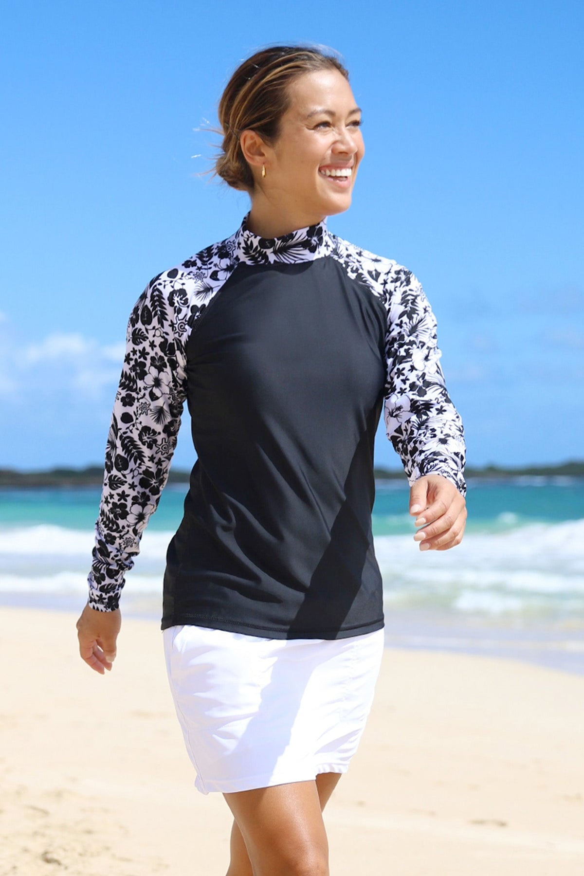 Woman Walking Down the Beach Smiling in the Women's Aloha Long Sleeve Sun & Swim Shirt in Black Aloha|black-aloha