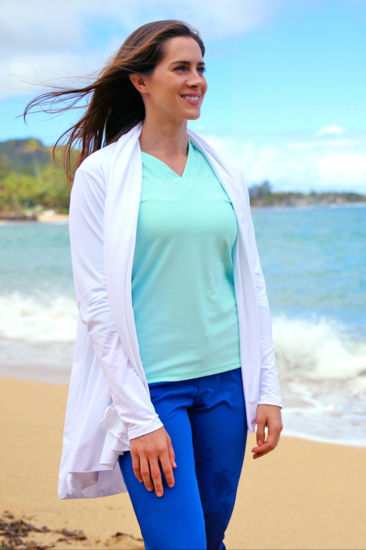 Woman wearing UV Skinz's women's hooded beach cover up in white|white