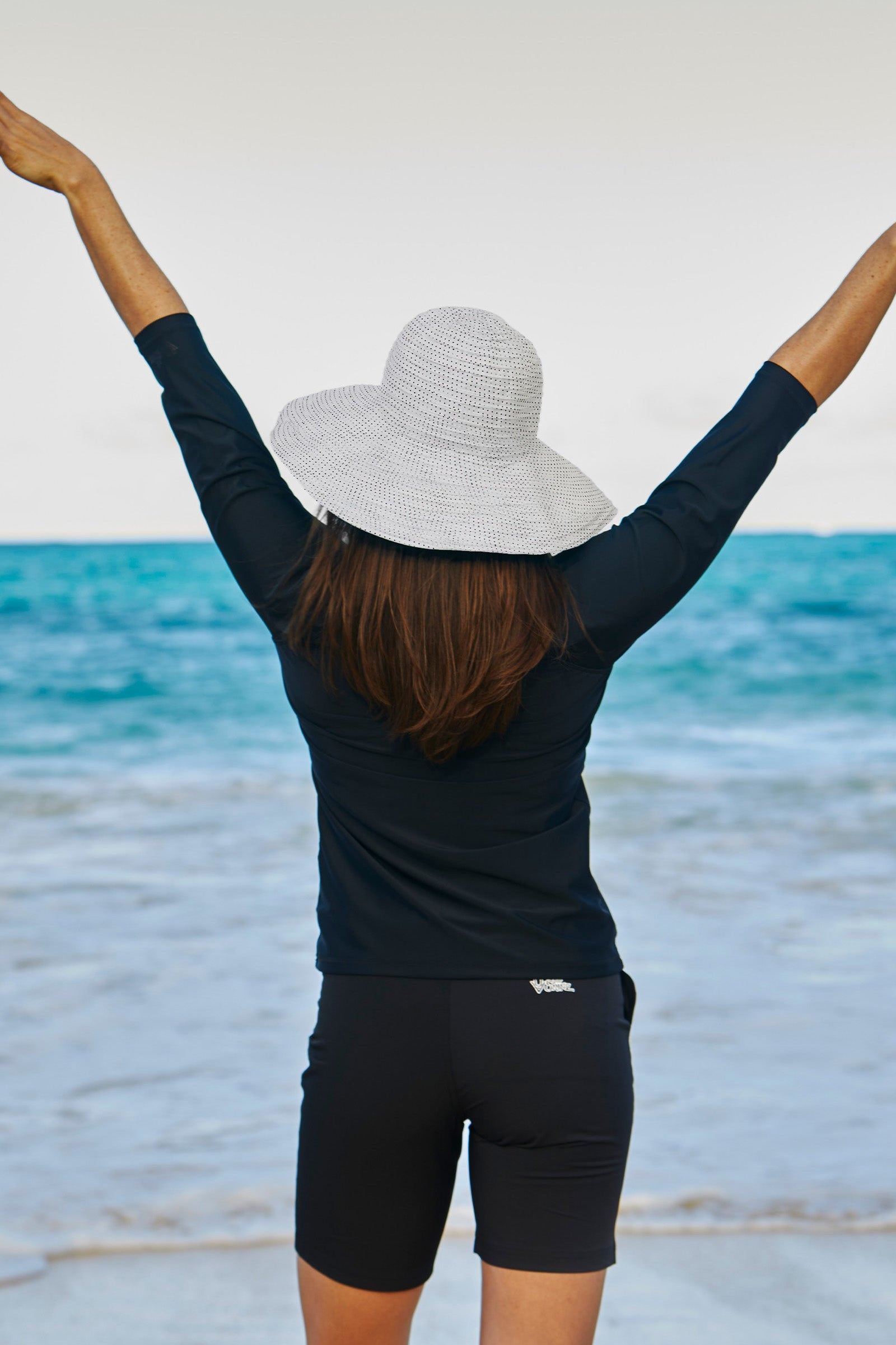 Woman in UV Skinz's wide brim sun hat|white